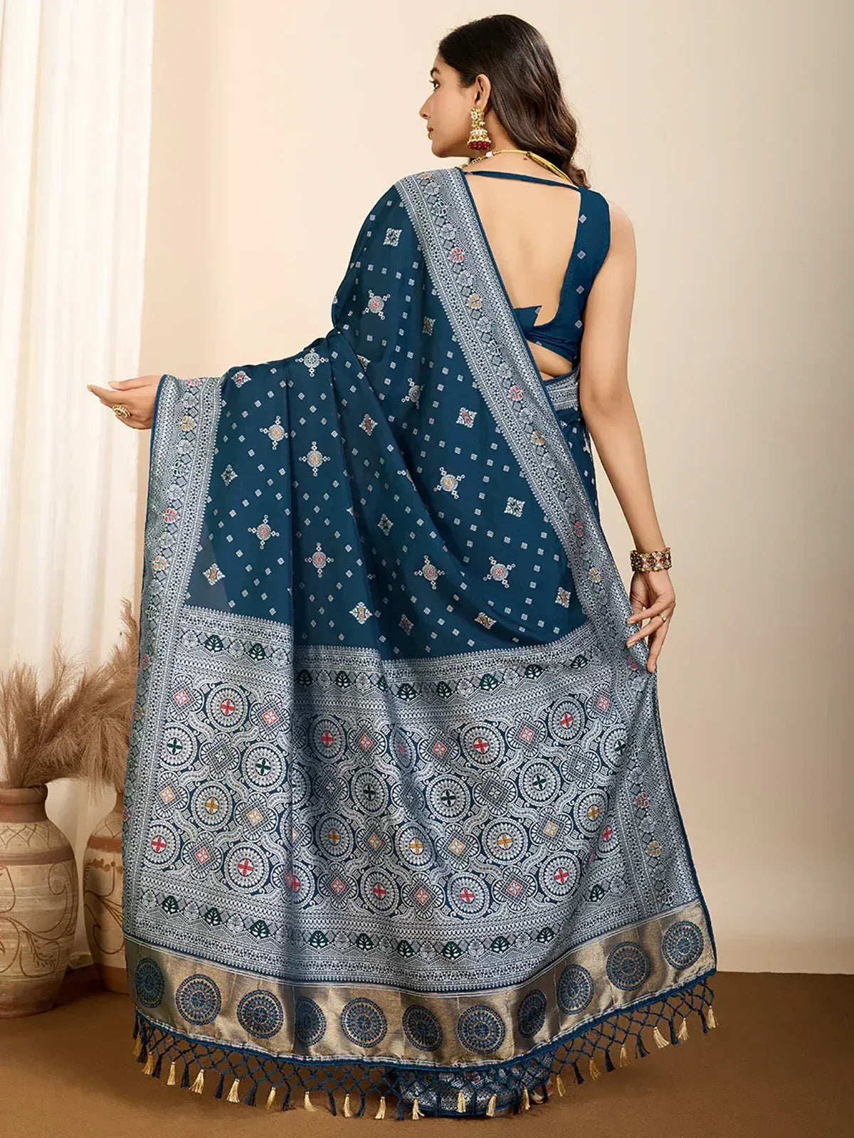 Blue printed saree with intricate border and tassels, paired with backless blouse for ethnic wear