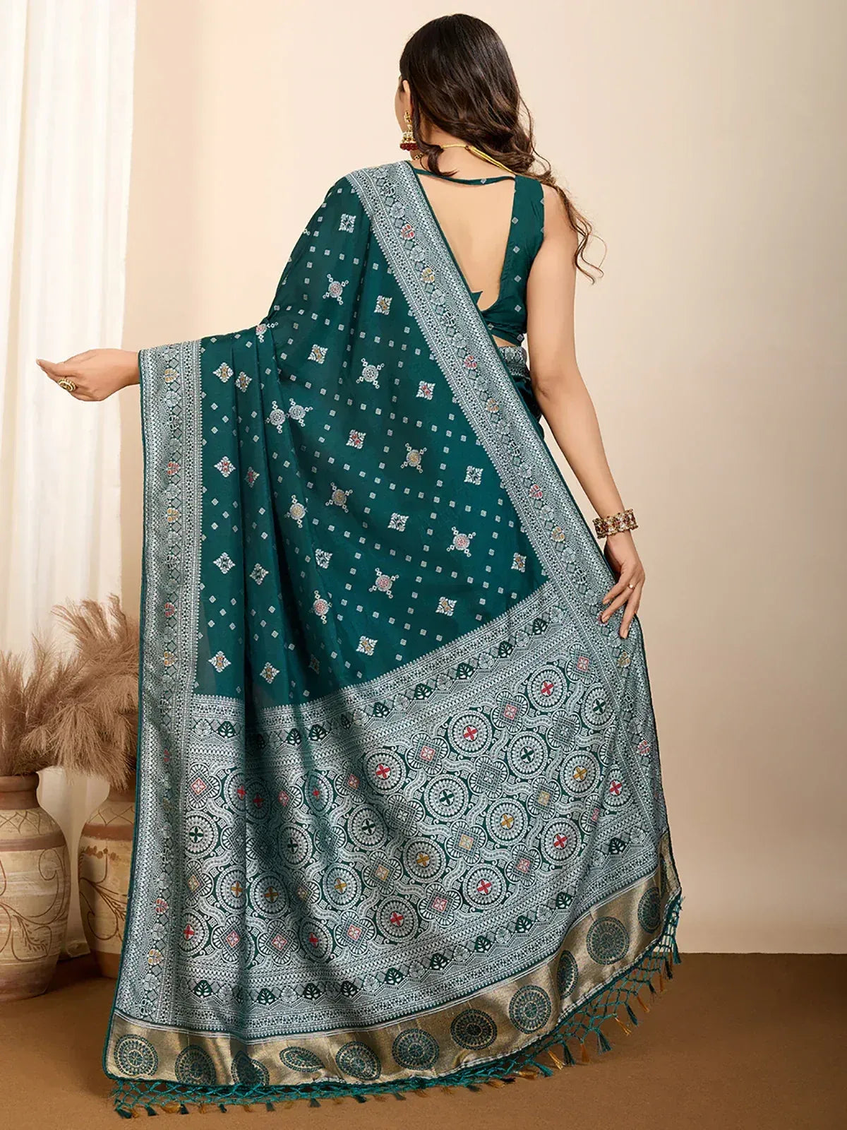 Teal printed saree with intricate border and tassels, paired with backless blouse for ethnic wear