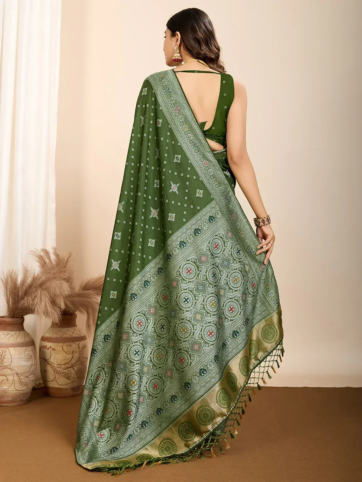 Green printed saree with intricate border and tassels, paired with backless blouse, ethnic wear