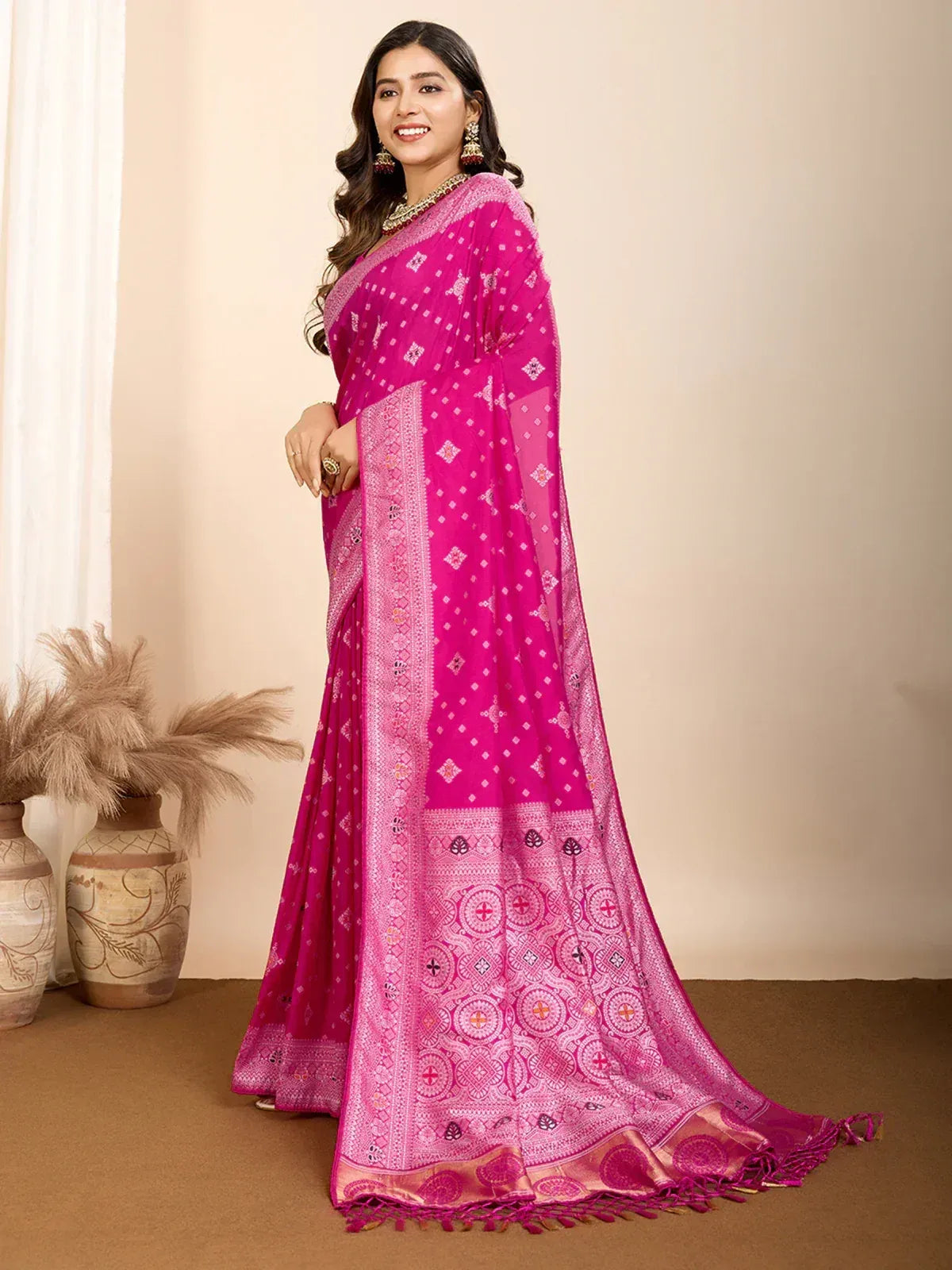 Vibrant pink ethnic saree with intricate patterns and golden border, perfect for festive occasions.