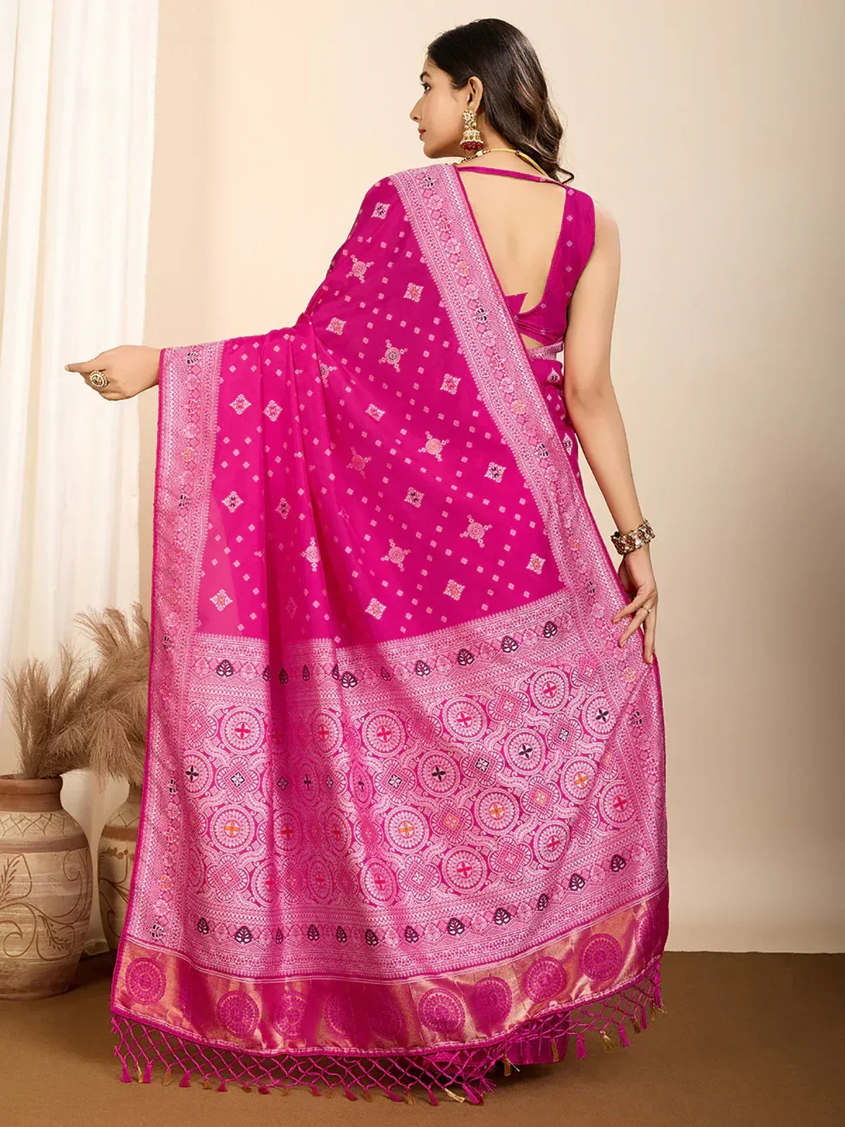Vibrant pink ethnic saree with intricate geometric patterns and golden border, perfect for festive occasions