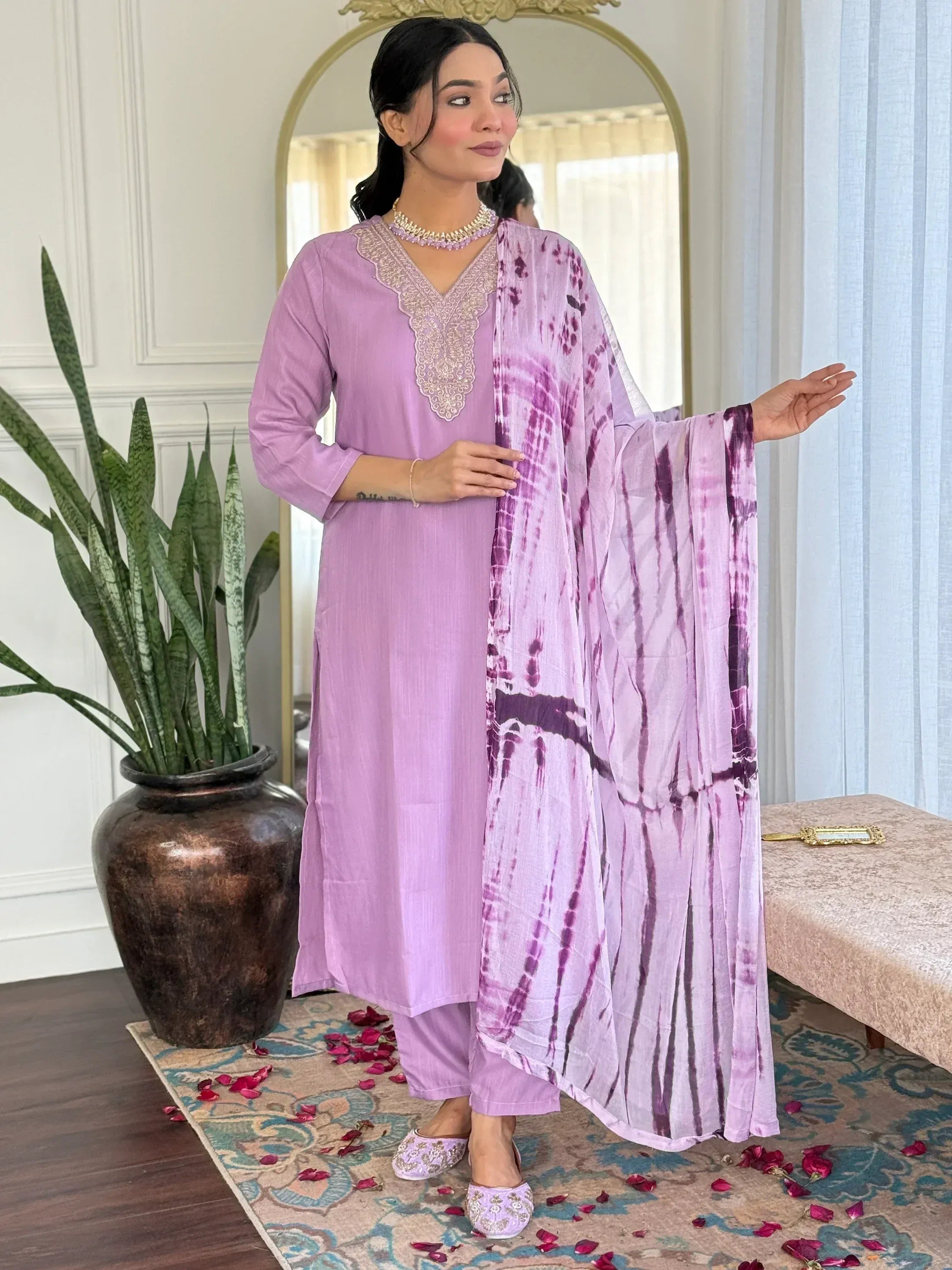Lavender ethnic salwar kameez with embroidered neckline and tie-dye dupatta, styled for festive occasions.