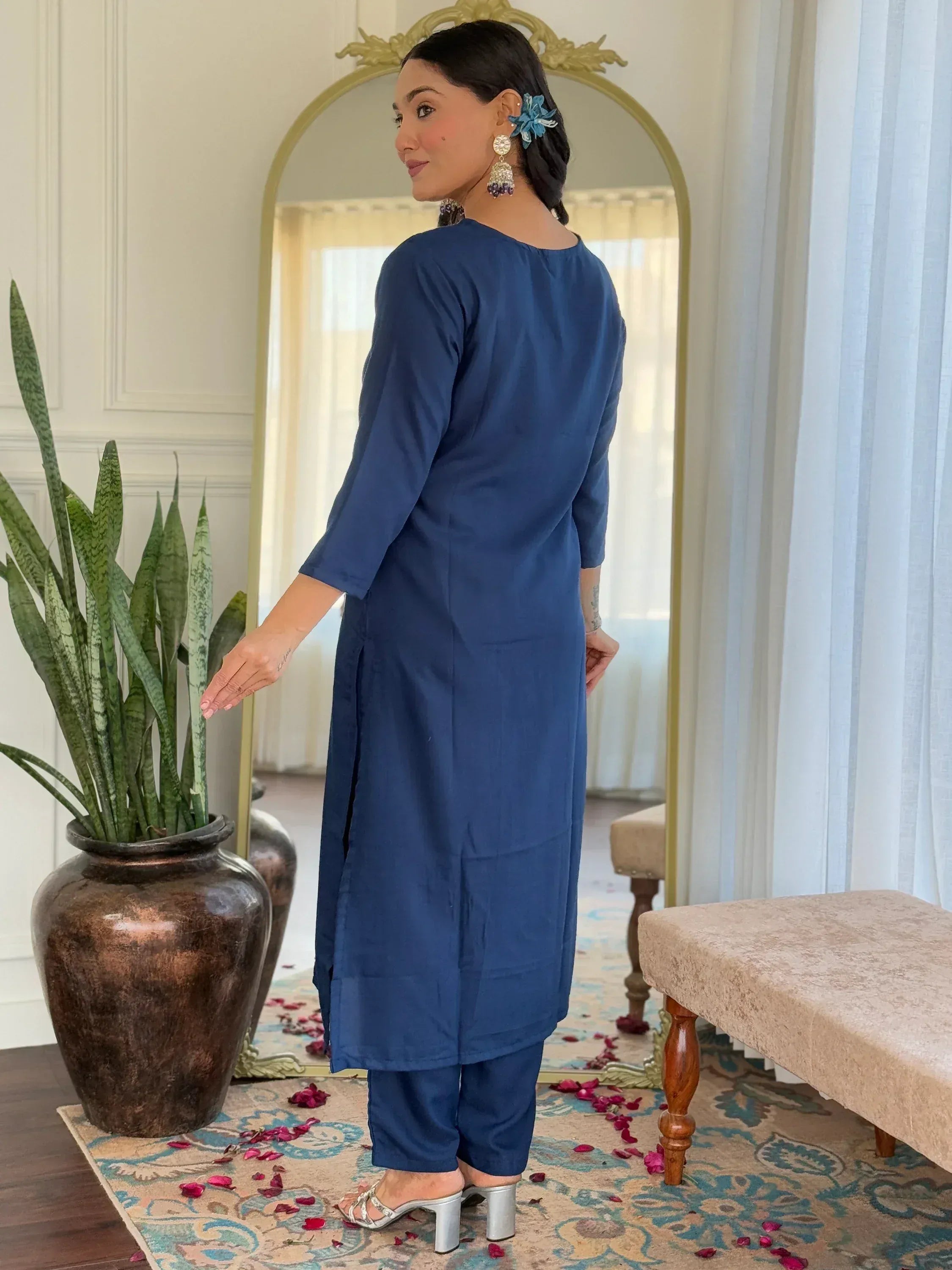 Woman in blue ethnic kurta and pants, showcasing back view with mirror and rose petals