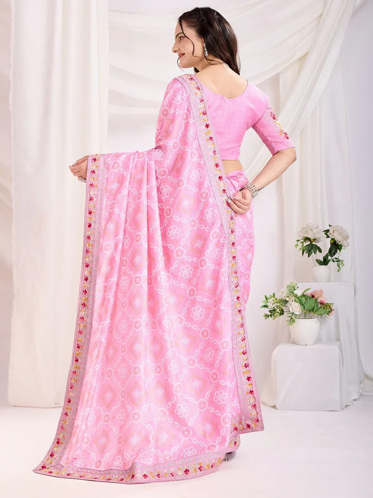 Pink printed saree with floral border, paired with matching blouse, ideal for ethnic occasions