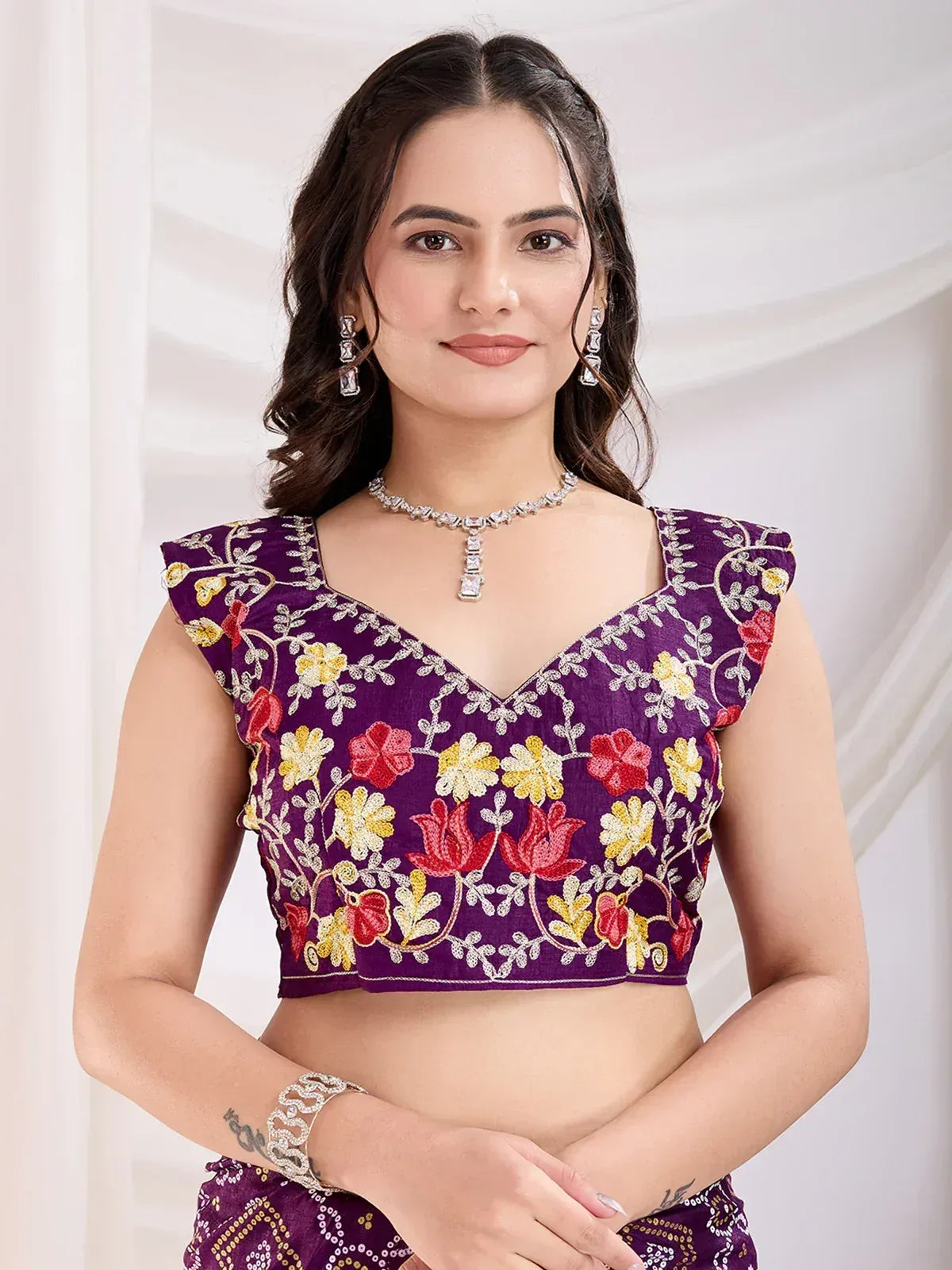 Purple floral embroidered lehenga choli top with V-neck and cap sleeves, paired with matching skirt
