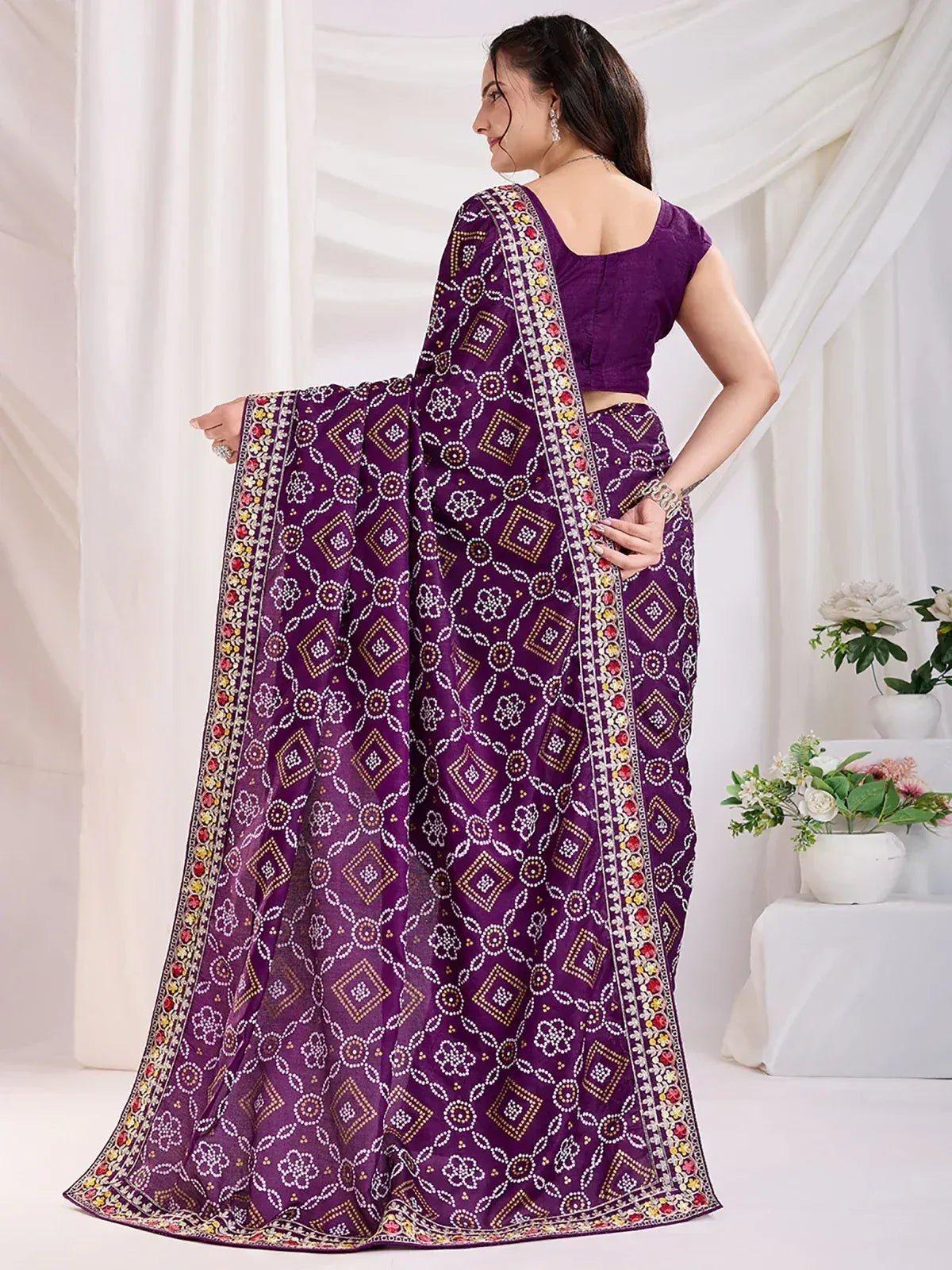 Purple printed saree with floral and geometric patterns, paired with matching blouse, ideal for ethnic occasions.