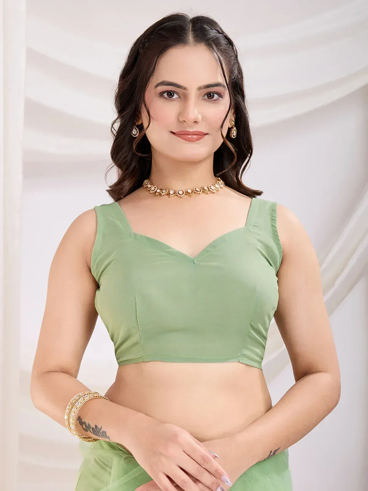 Mint green sleeveless blouse with V-neck, perfect for saree or lehenga, paired with gold jewelry
