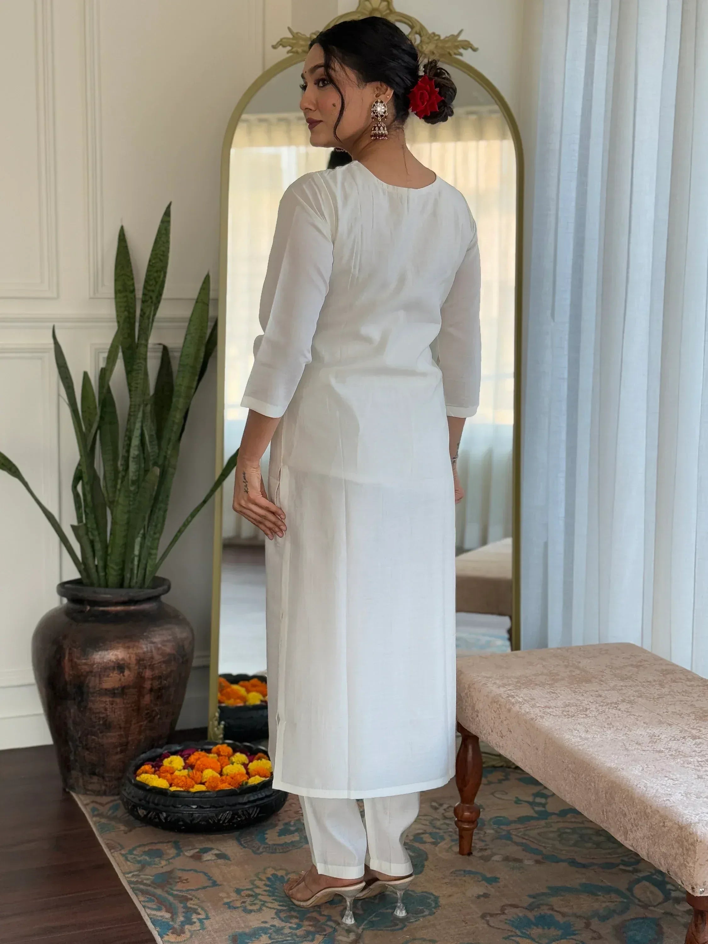 White ethnic kurta with pants, traditional Indian wear for women, styled with jhumka earrings and floral hair accessory
