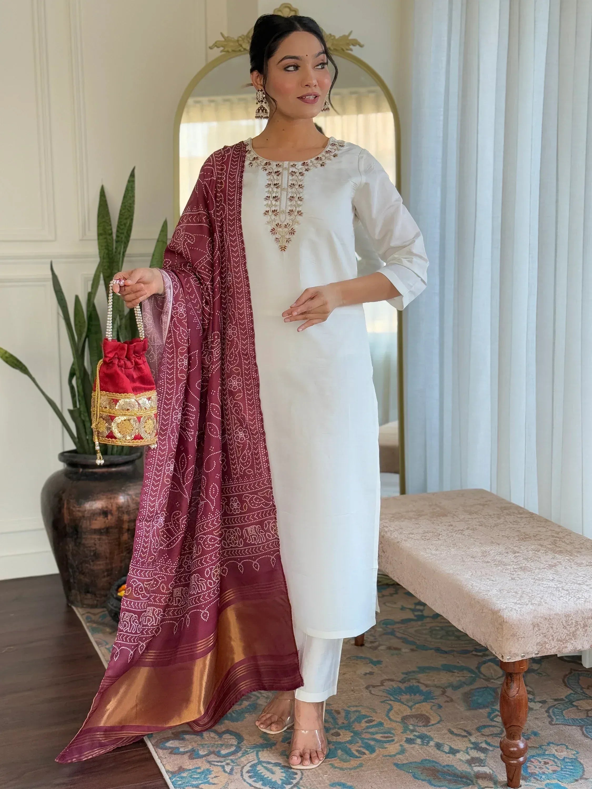 White embroidered kurta with maroon bandhani dupatta and red potli bag, Indian ethnic wear