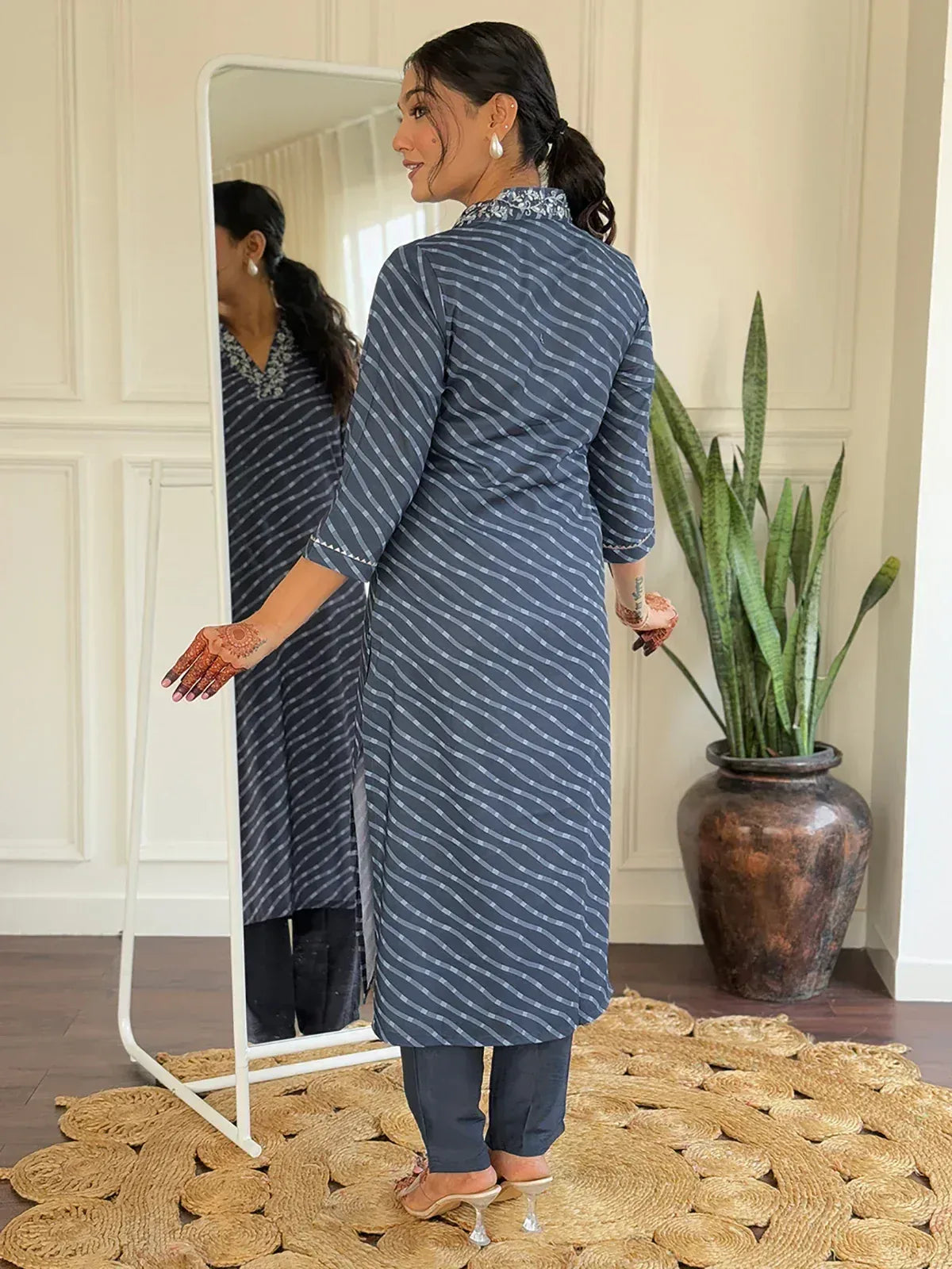Woman in blue striped kurta with embroidery, paired with pants, henna hands, mirror reflection