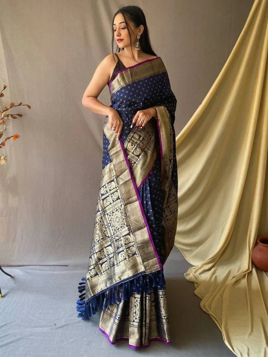 Woman in navy blue and gold ethnic saree with elephant print and purple border, perfect for Indian occasions