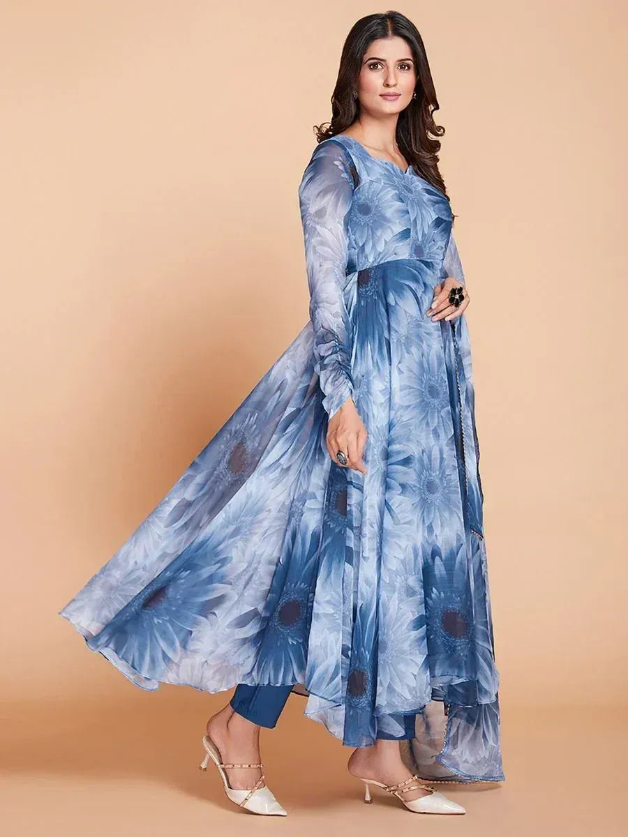 Blue floral print ethnic gown with long sleeves and layered skirt, paired with white heels