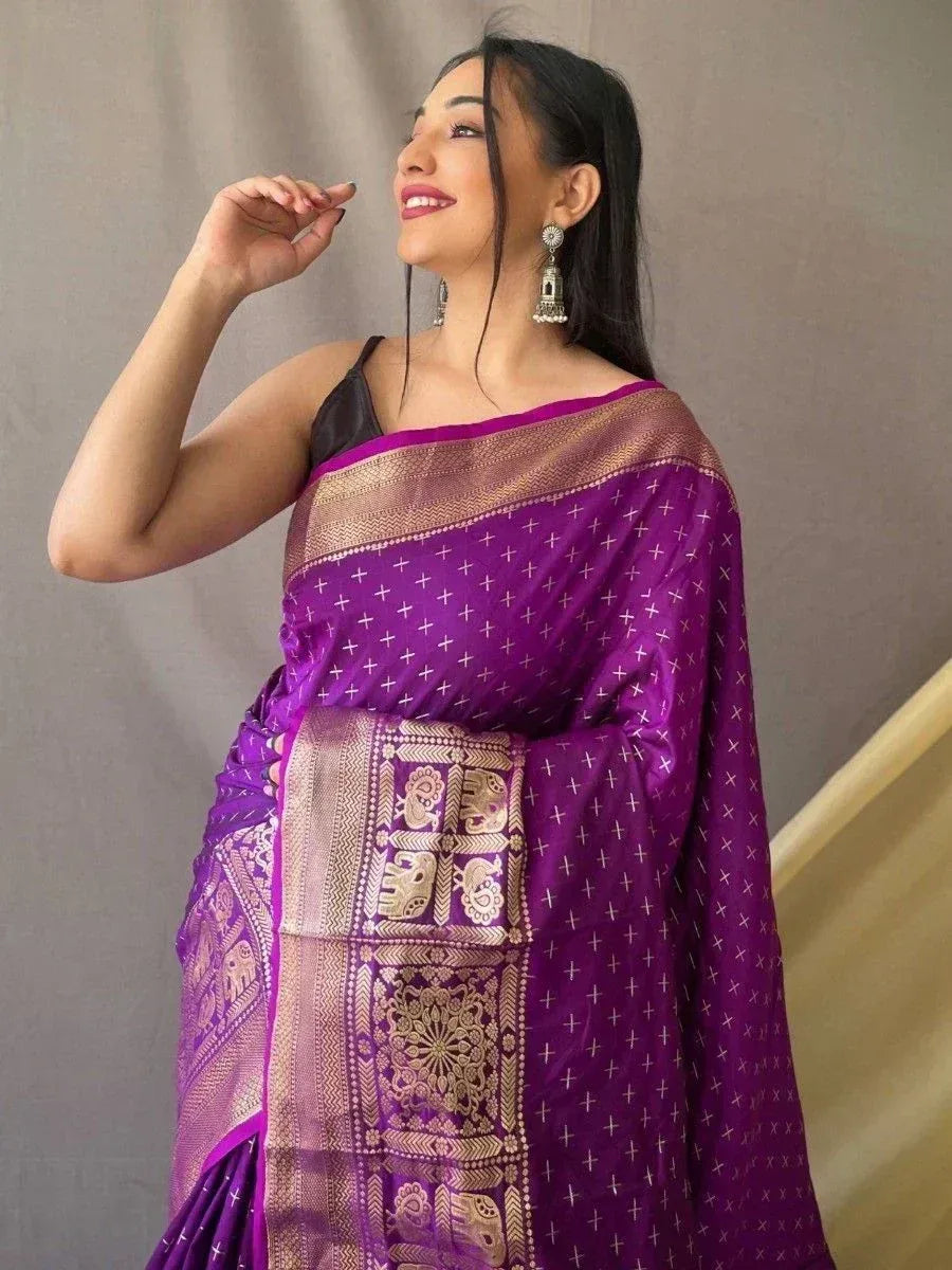 Purple ethnic saree with gold elephant motifs and cross pattern, styled with black blouse and jhumka earrings
