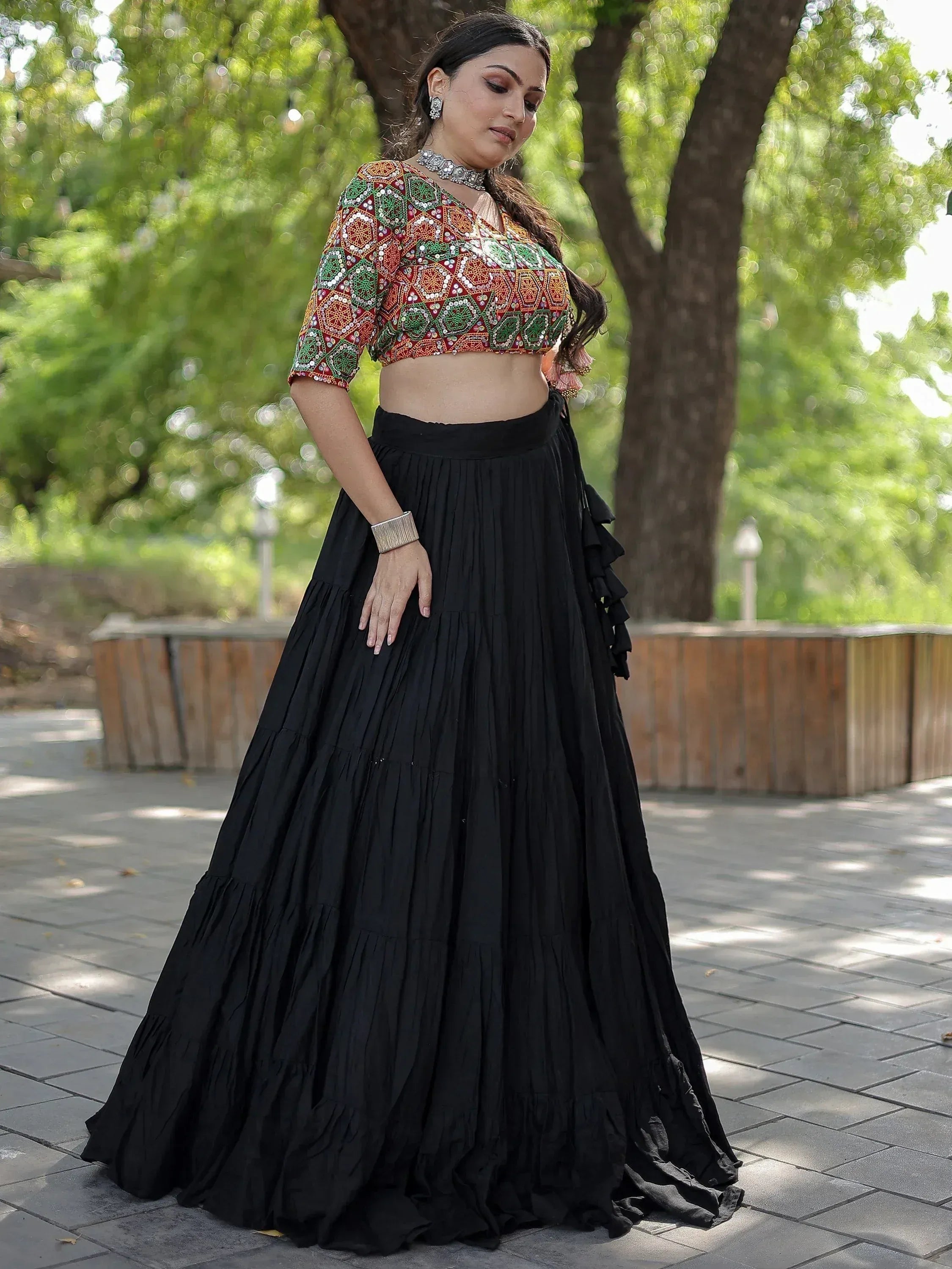Woman in embroidered crop top and black pleated lehenga skirt, Indian ethnic wear
