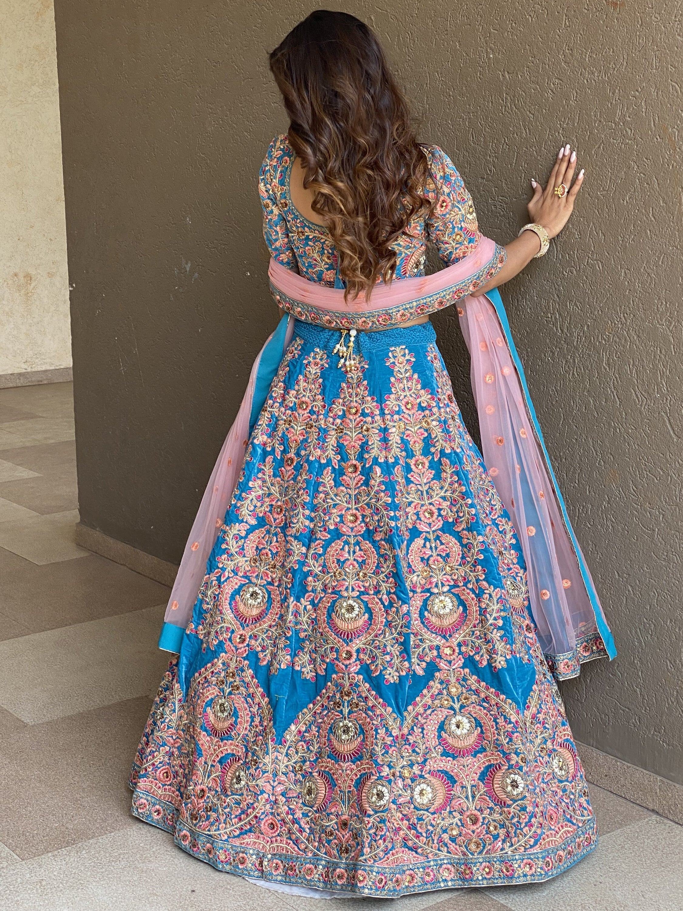 Blue and pink embroidered lehenga choli with floral motifs, perfect for Indian weddings and festive occasions.