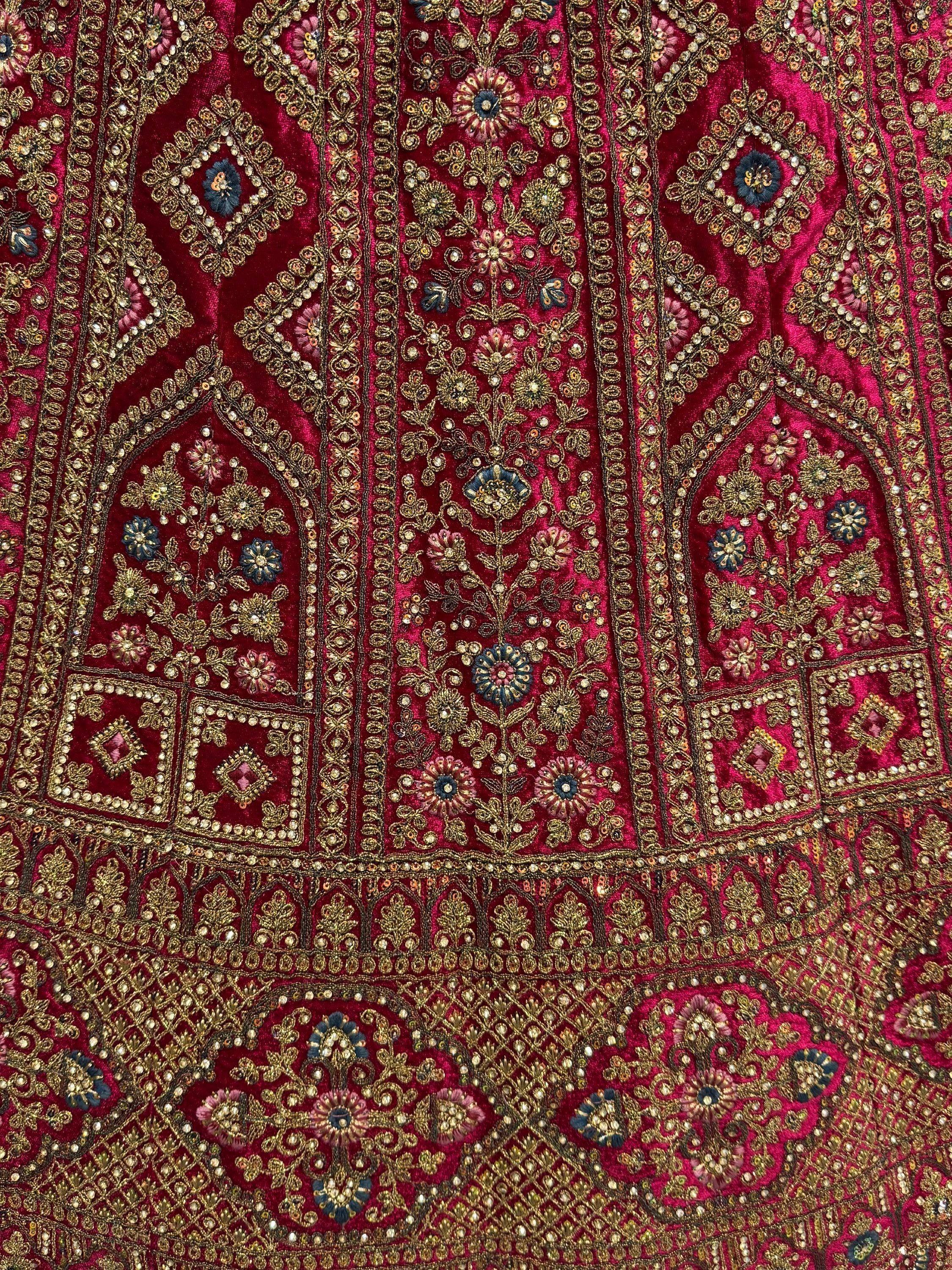 Richly embroidered maroon velvet Indian ethnic wear with gold floral motifs and beadwork details