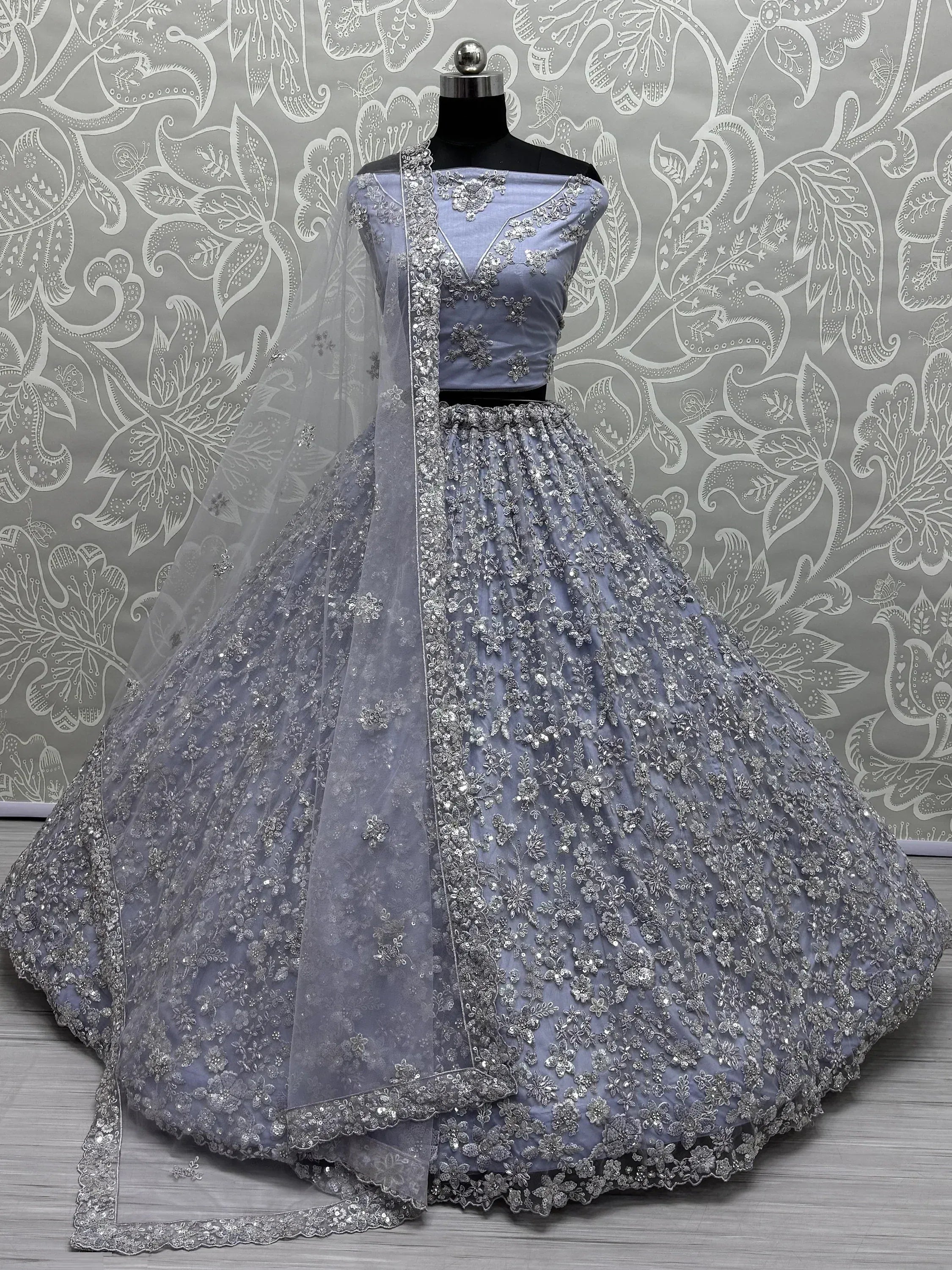 Elegant lavender lehenga choli with silver floral embroidery and sheer dupatta, perfect for Indian weddings and festive occasions.