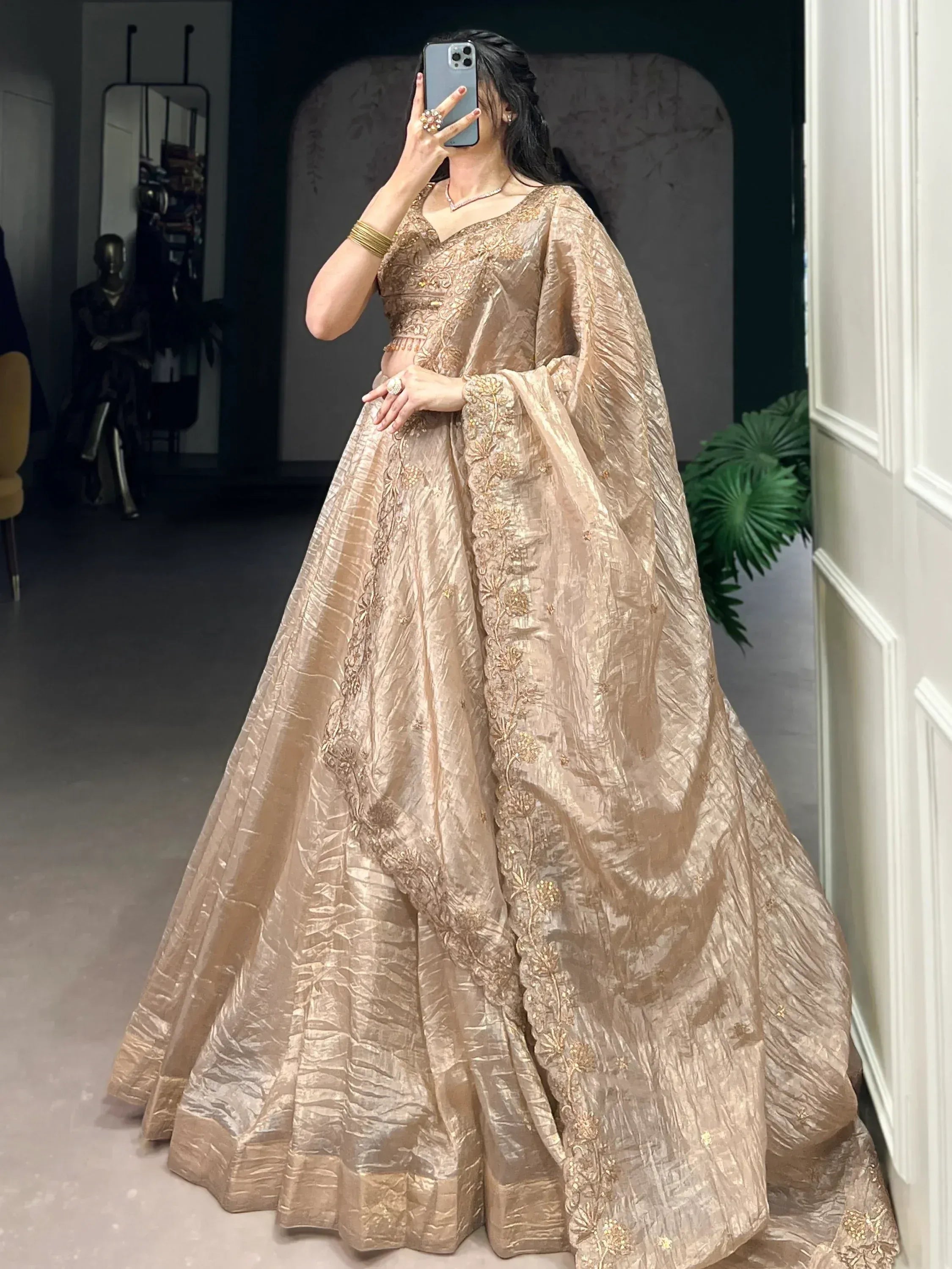 Elegant gold embroidered lehenga choli with sheer dupatta, perfect for Indian weddings and festive occasions.