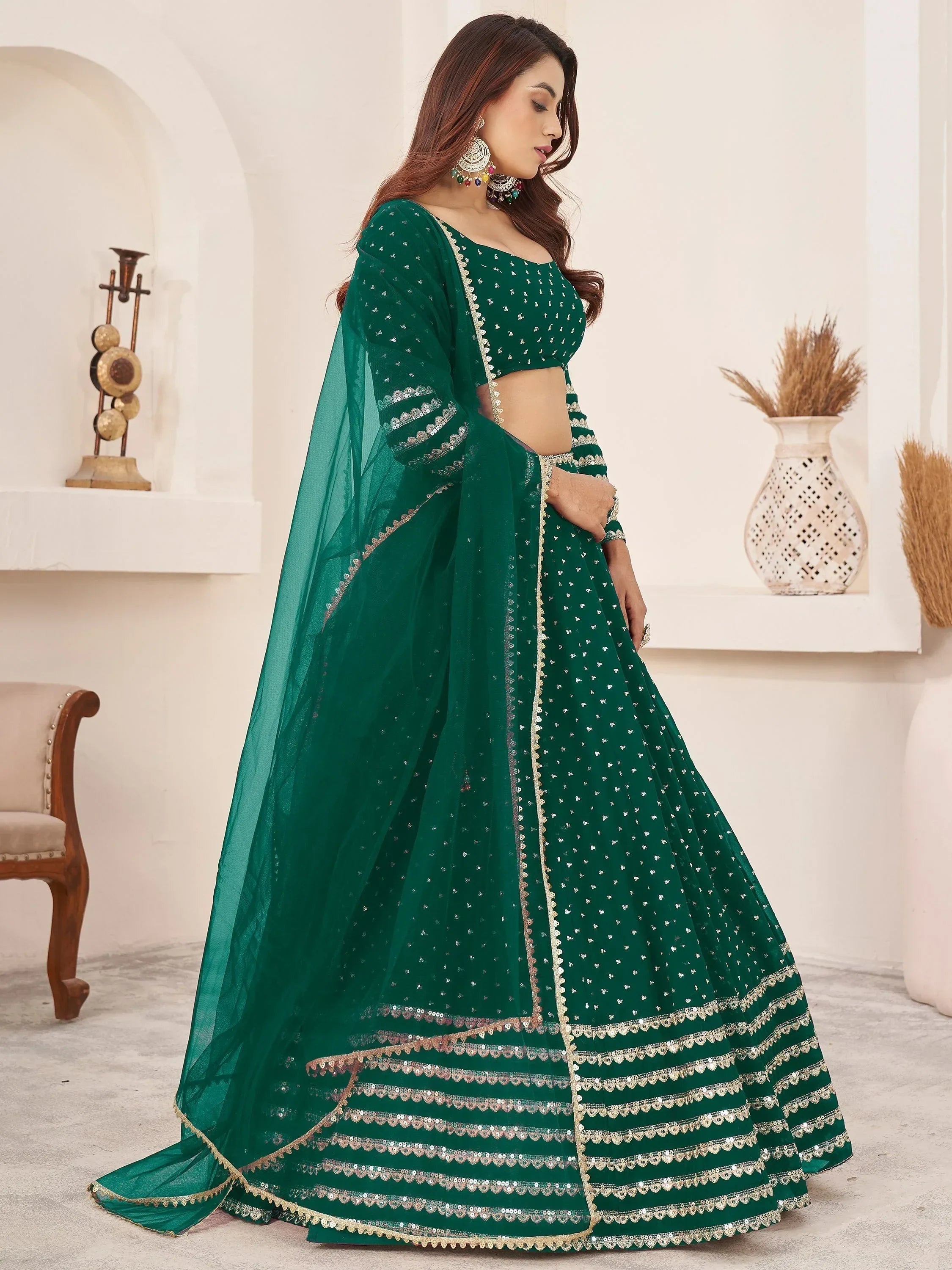 Emerald green designer lehenga choli with sequin work and gold trim, perfect for Indian weddings and festivals