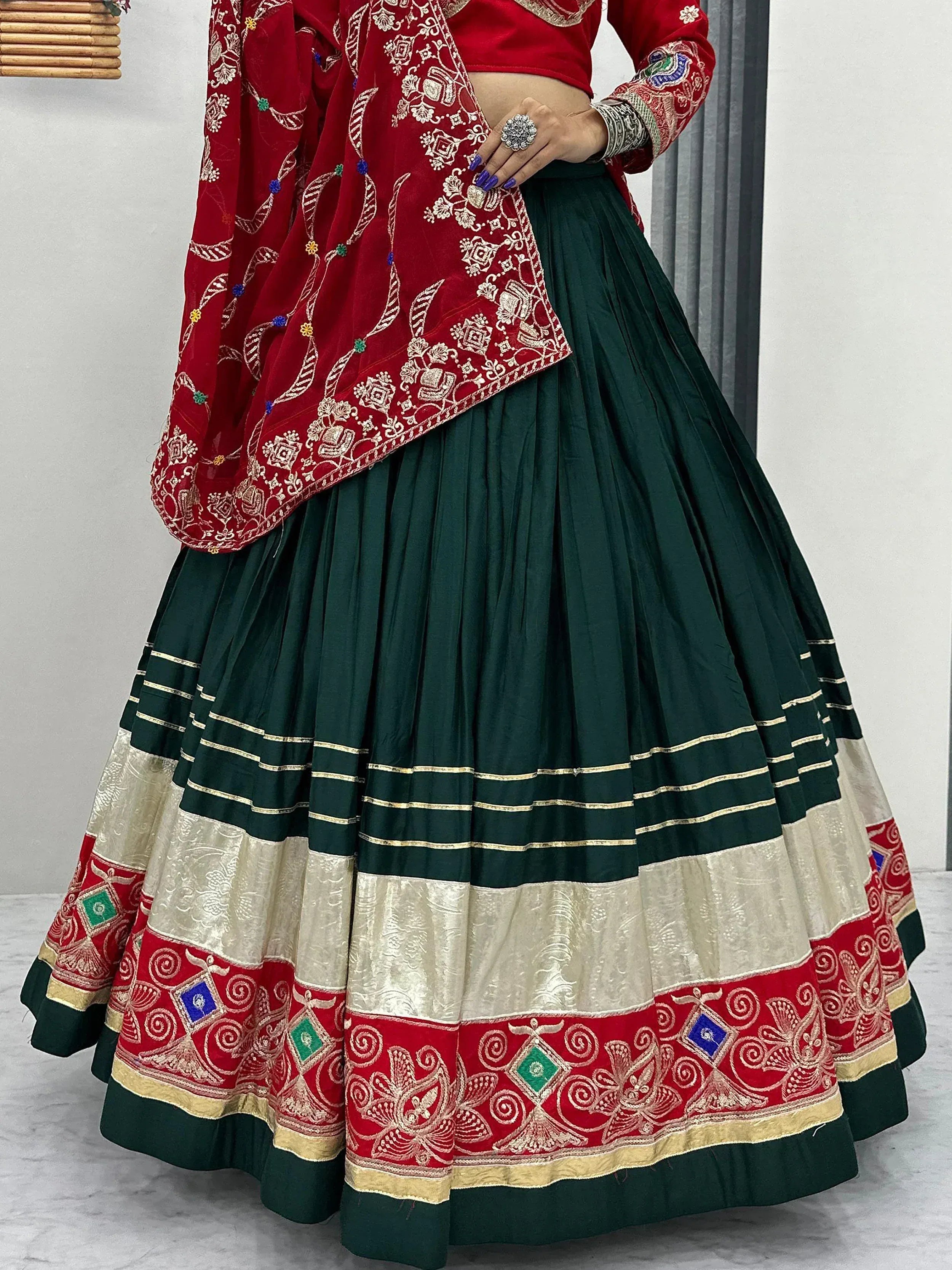 Red and green embroidered lehenga choli with gold detailing, perfect for Indian ethnic wear occasions.