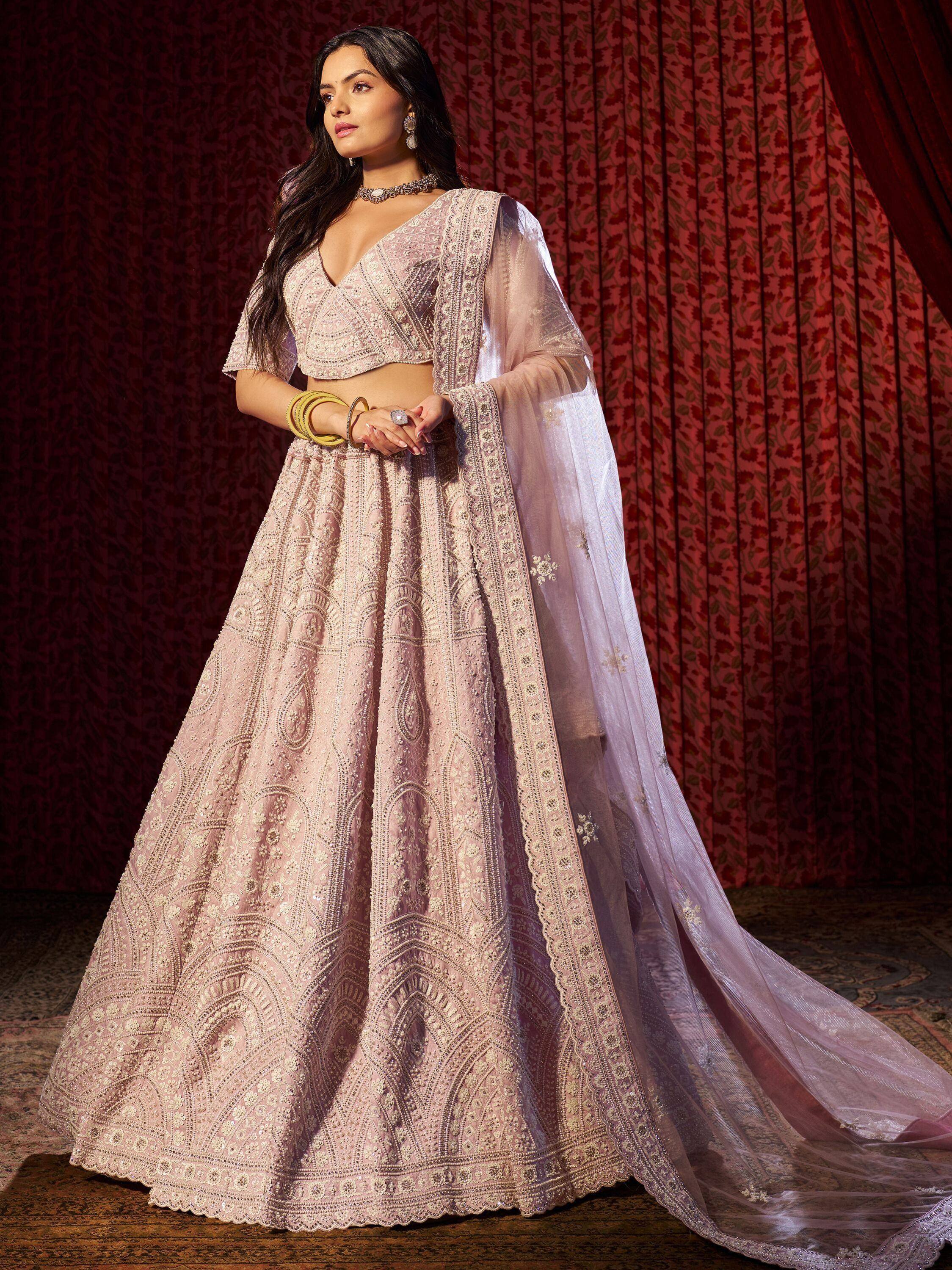Elegant pink embroidered lehenga choli with sheer dupatta, perfect for Indian weddings and festive occasions.