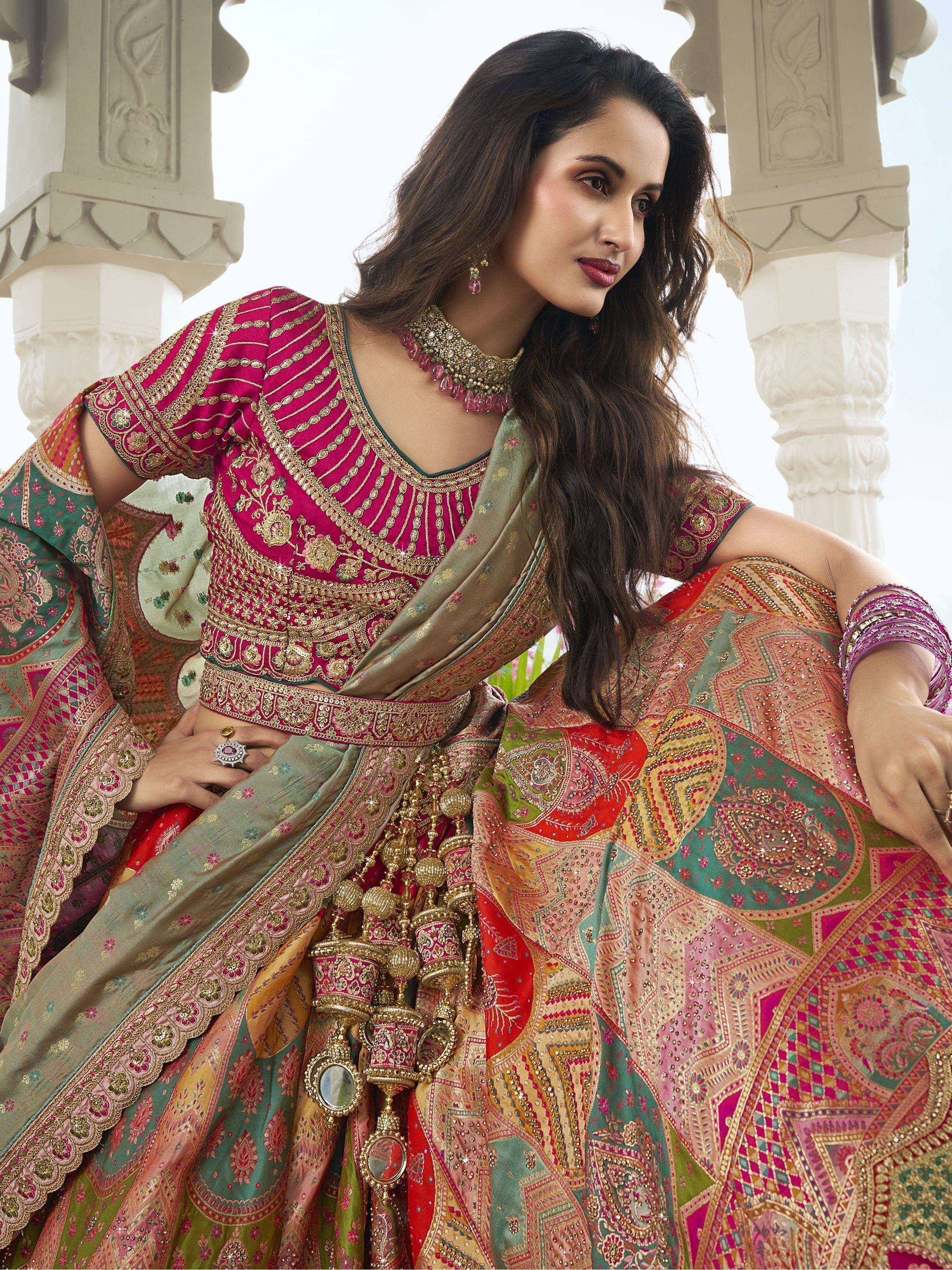 Woman in vibrant pink and green embroidered lehenga choli with mirror work, perfect for Indian ethnic occasions