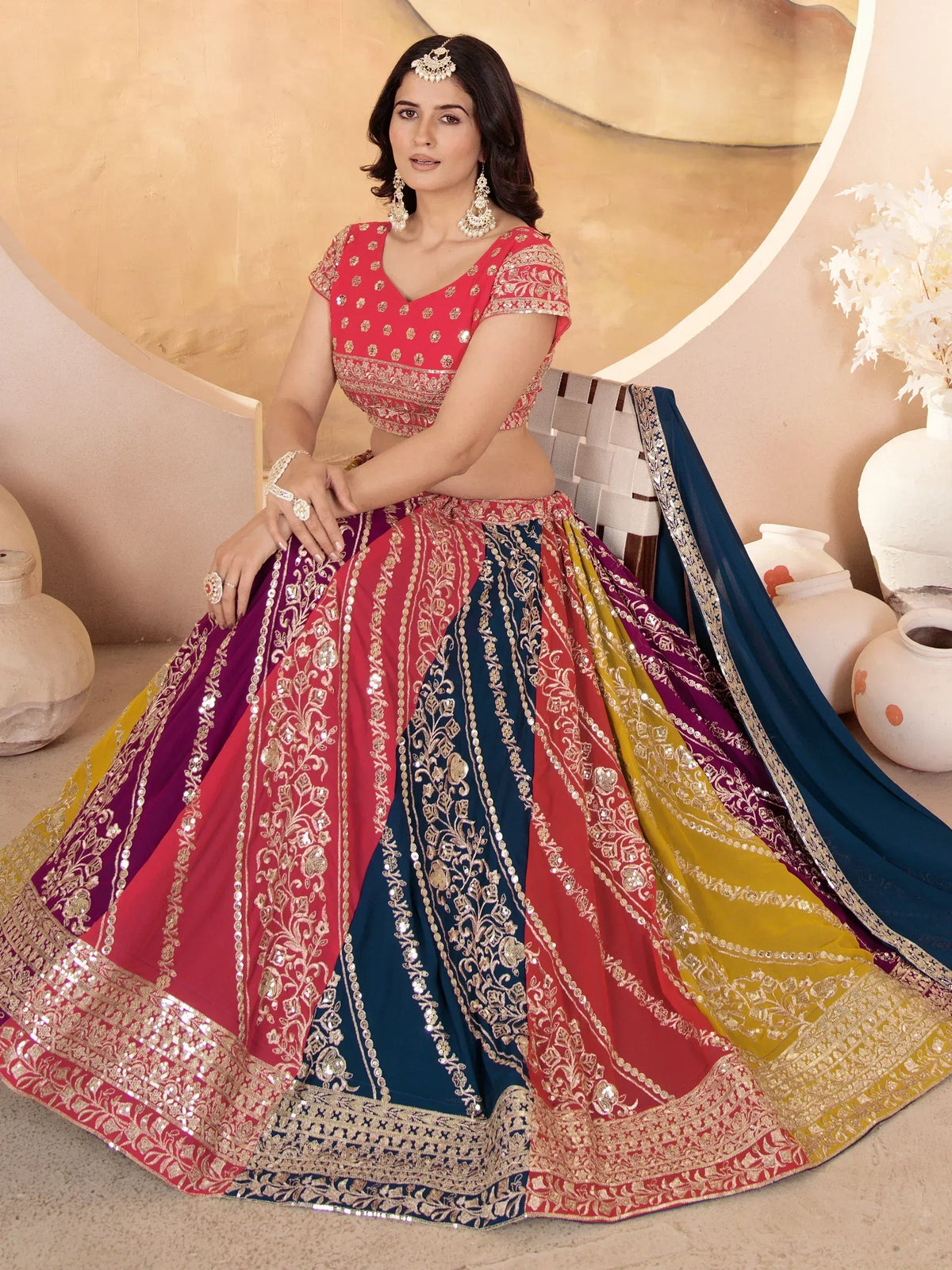 Woman in vibrant multi-color lehenga choli with gold embroidery and sequins, perfect for Indian ethnic occasions