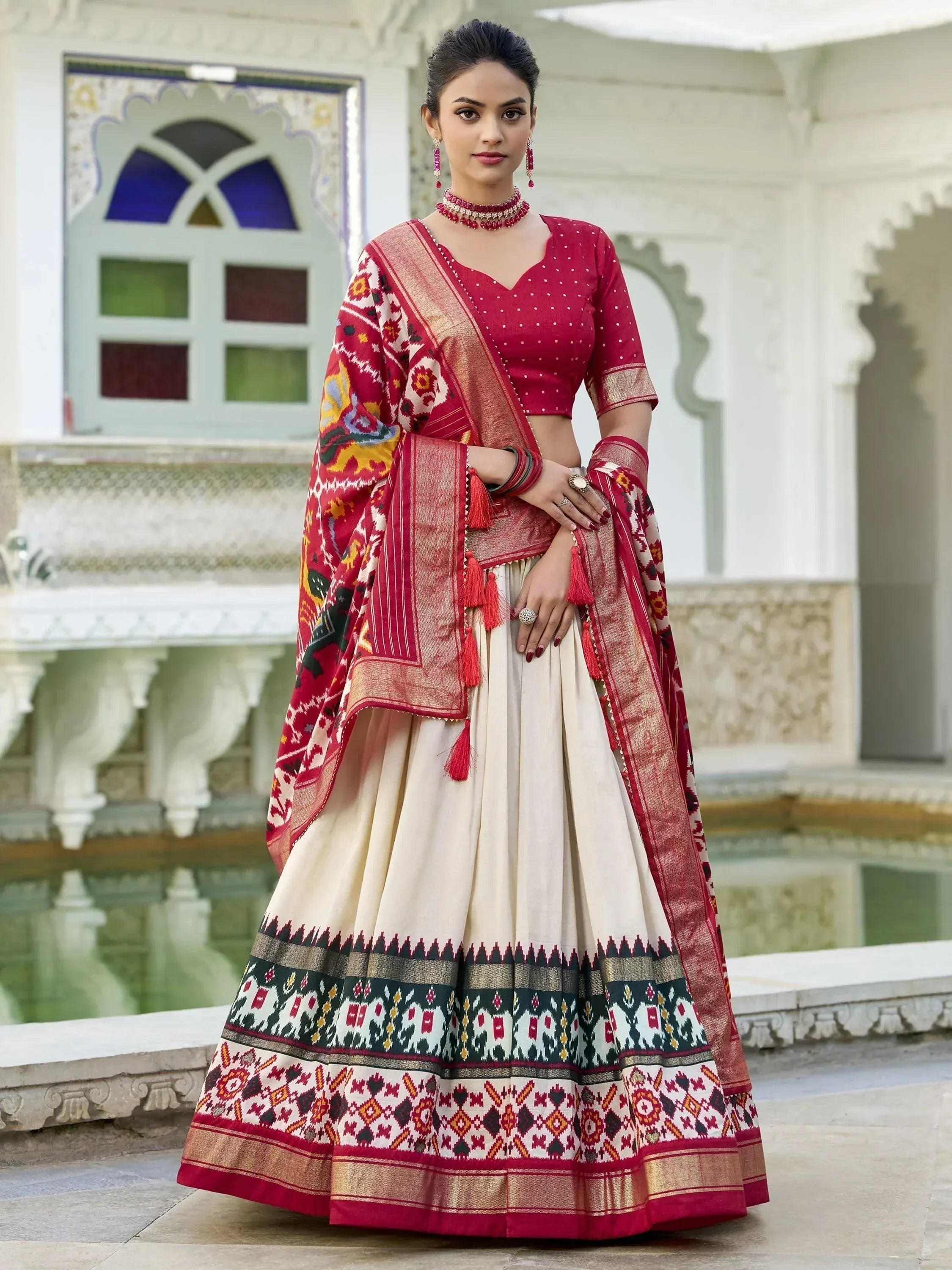 Red and cream ethnic lehenga choli with intricate ikat print, perfect for Indian weddings and festivals