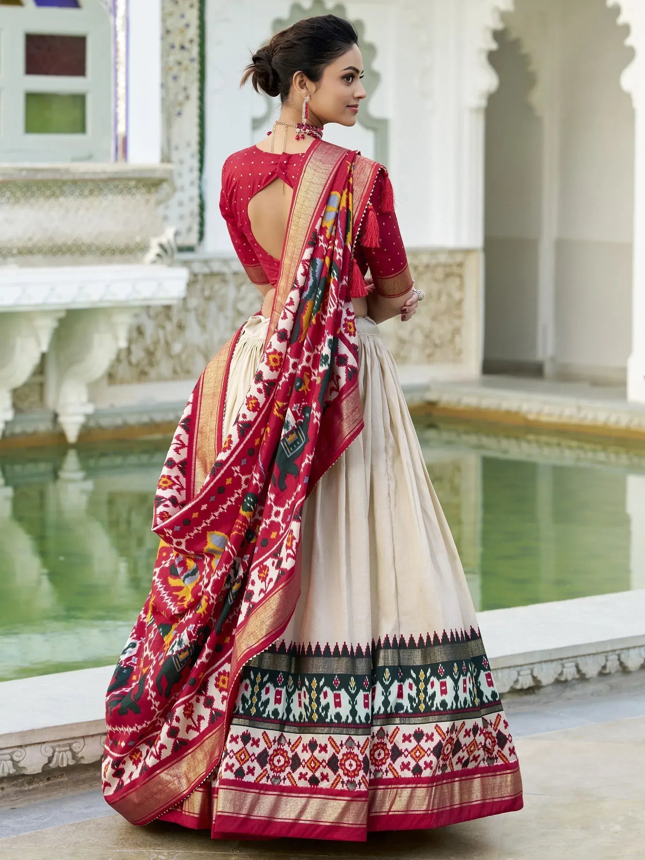 Red and cream ethnic lehenga choli with intricate ikat print, perfect for Indian weddings and festivals