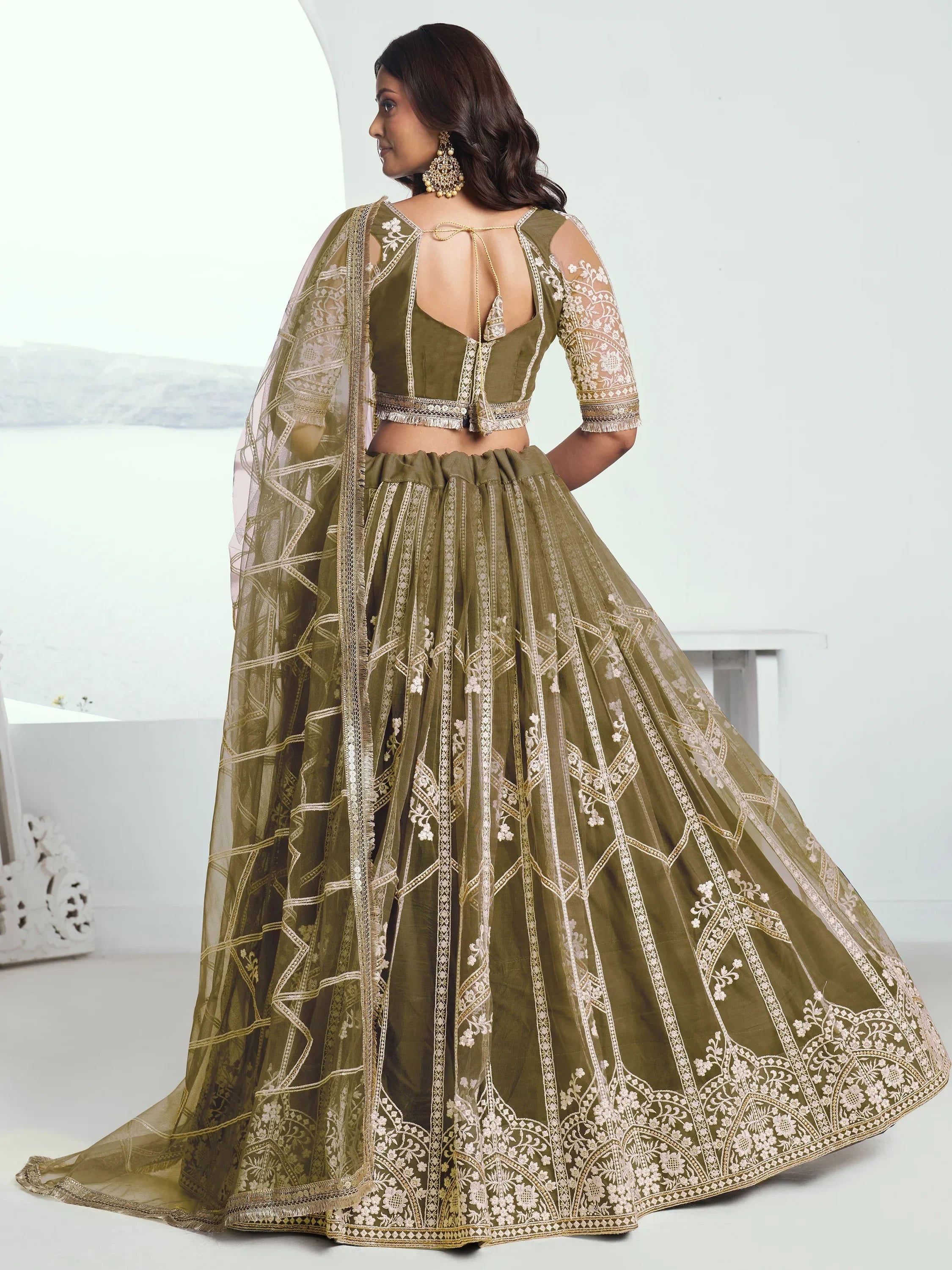 Olive green designer lehenga choli with intricate gold embroidery and sheer dupatta, perfect for weddings and festive occasions.