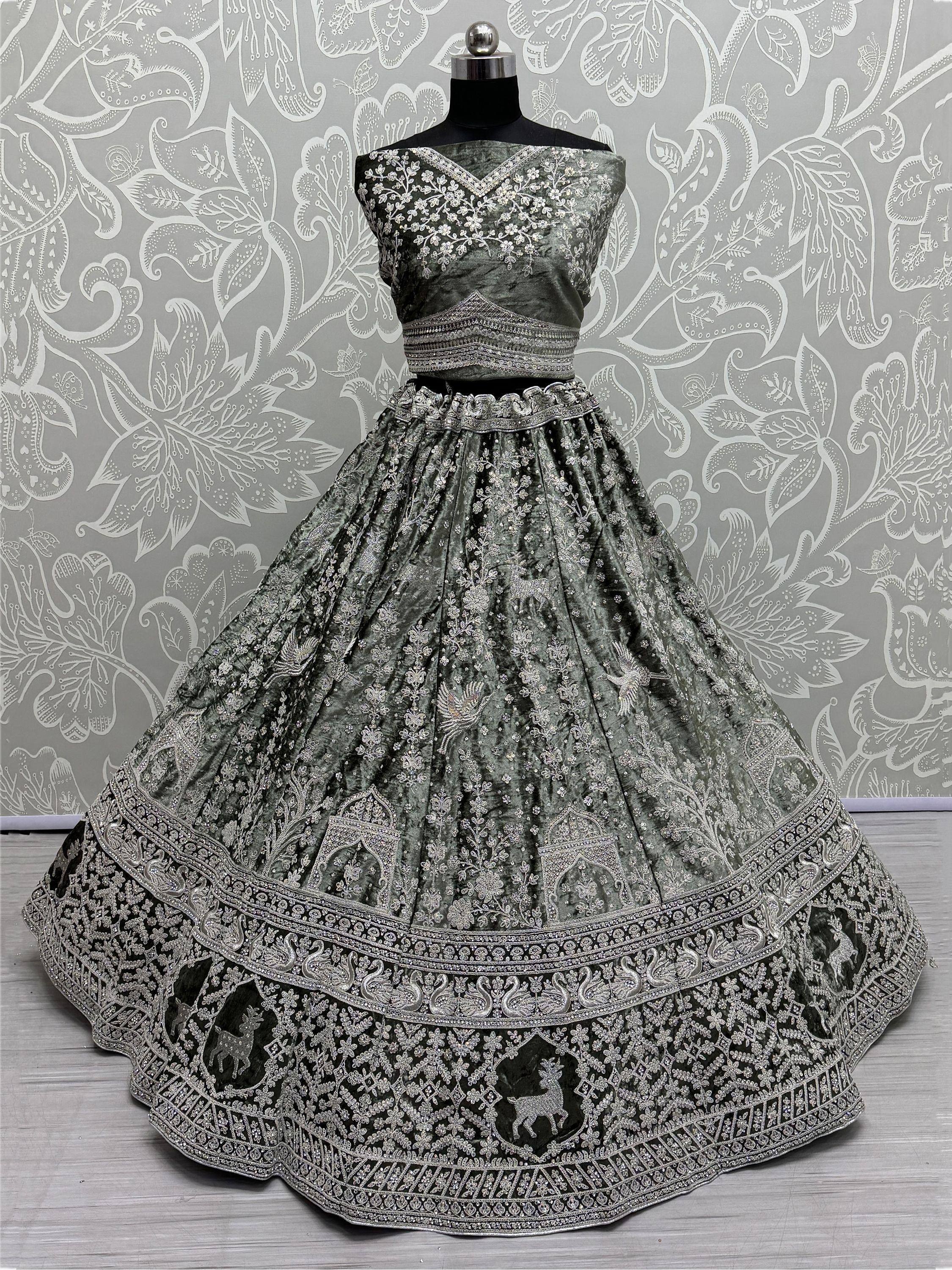 Emerald green velvet lehenga choli with silver embroidery, floral and deer motifs, perfect for Indian weddings and festive occasions.