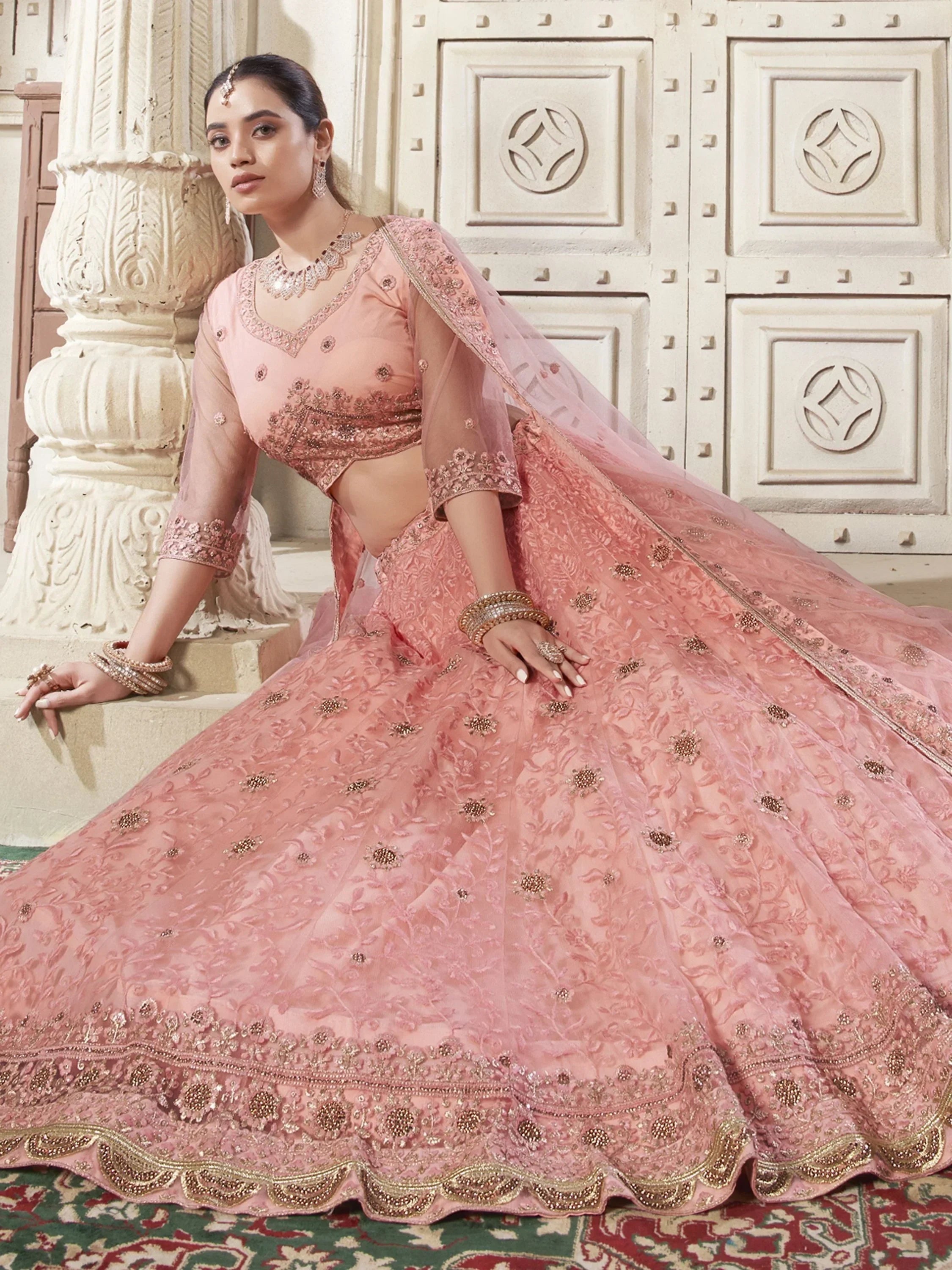 Pink designer lehenga choli with heavy embroidery and dupatta, perfect for weddings and festive occasions.