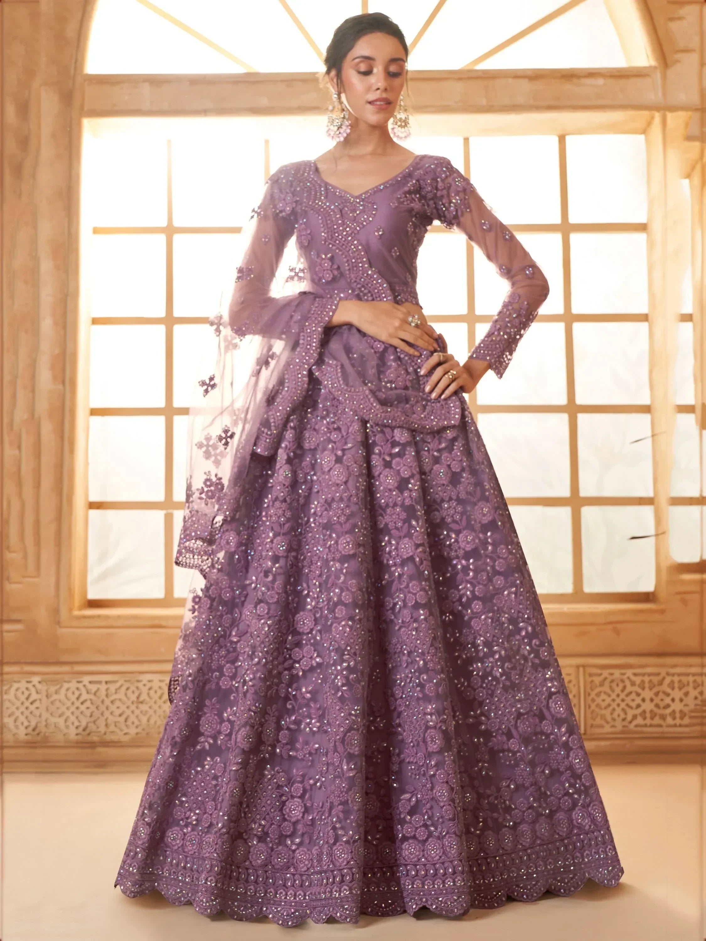 Elegant purple embroidered lehenga choli with sheer sleeves, perfect for Indian weddings and festive occasions.