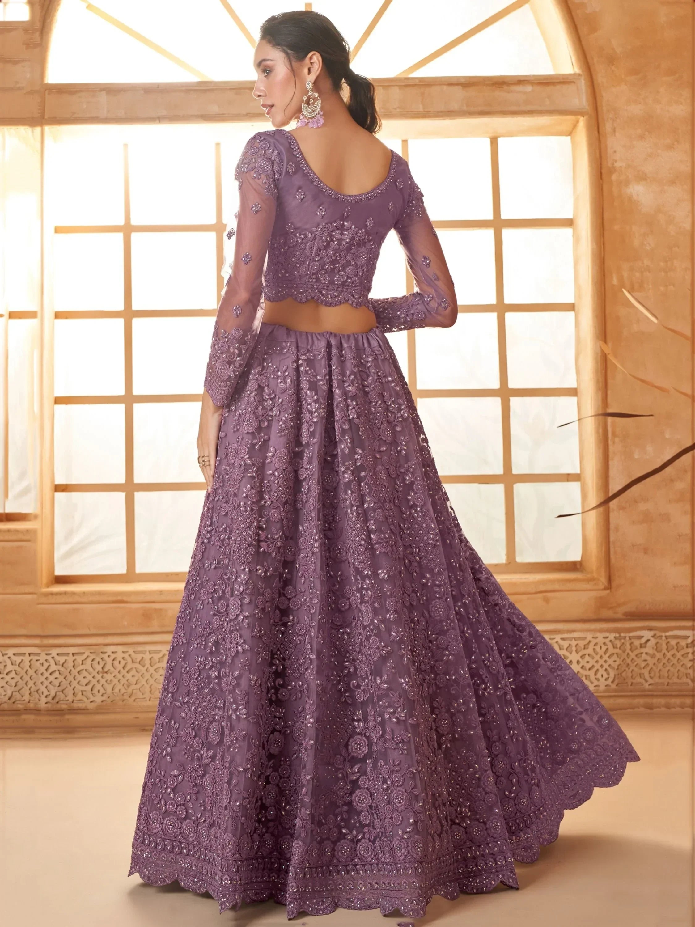 Purple embroidered lehenga choli with sheer sleeves, perfect for Indian weddings and festive occasions.