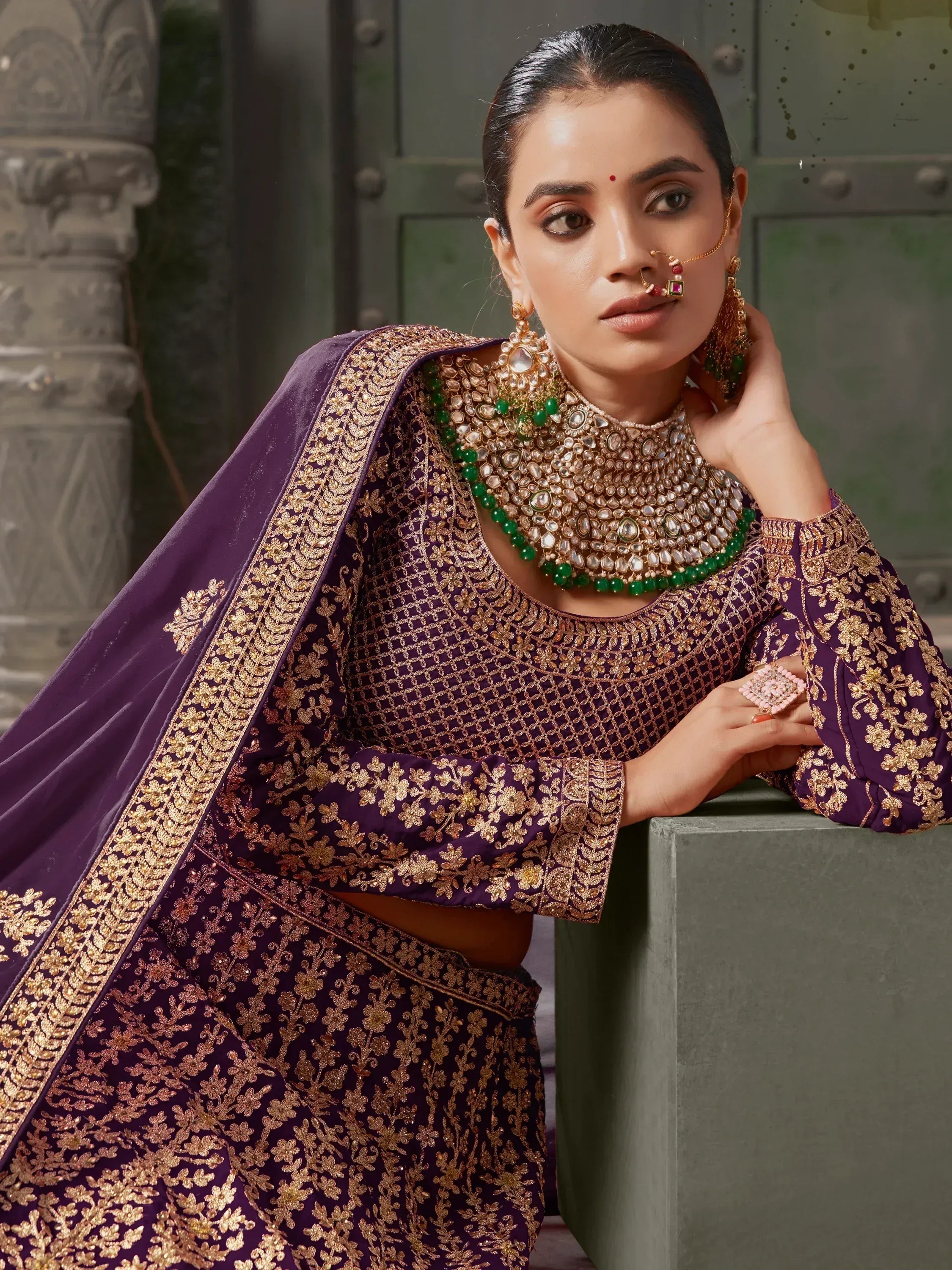 Purple embroidered lehenga choli with gold work and green jewelry for Indian ethnic wear