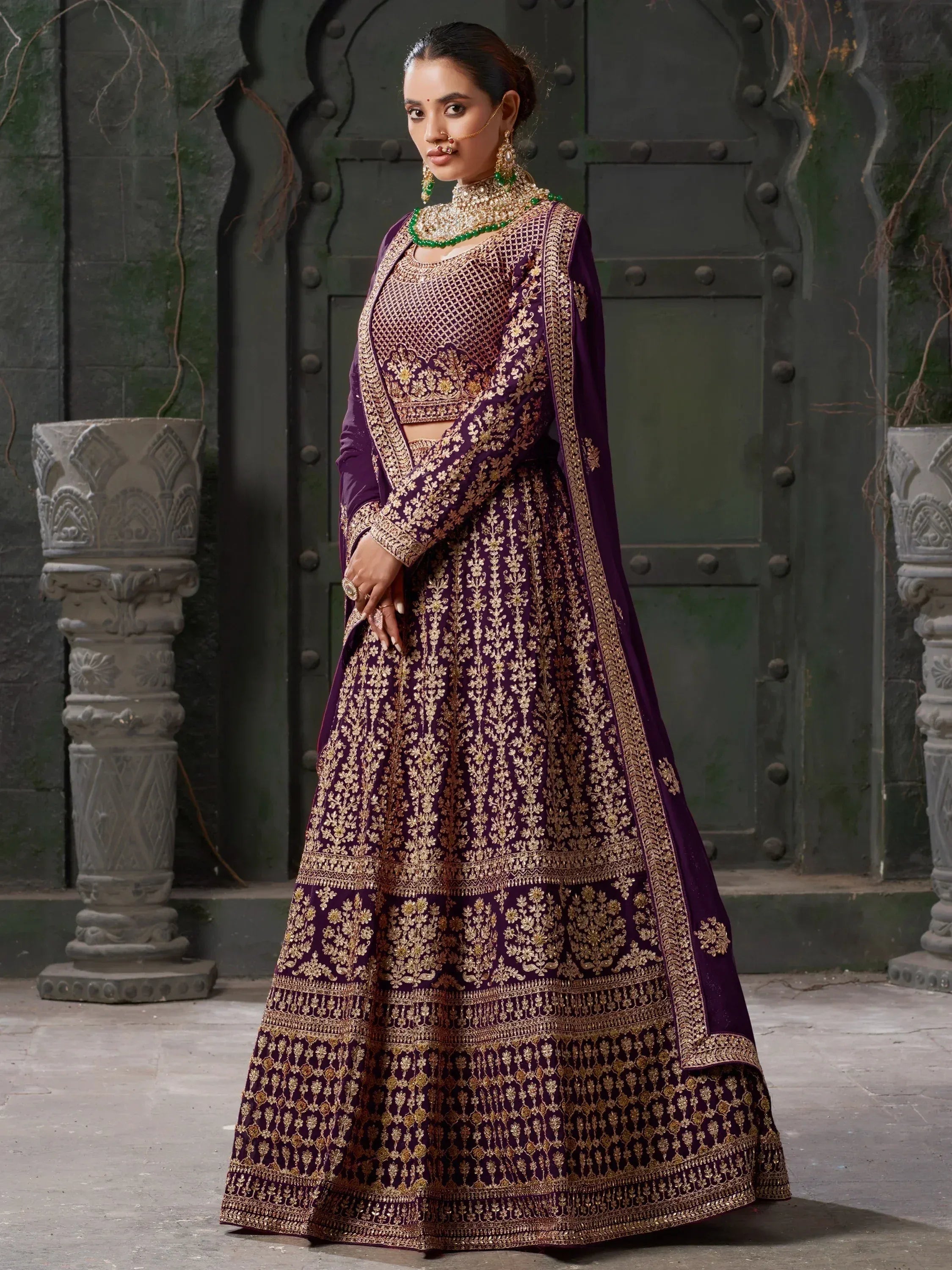 Purple and gold embroidered lehenga choli with heavy jewelry, perfect for Indian weddings and festive occasions.