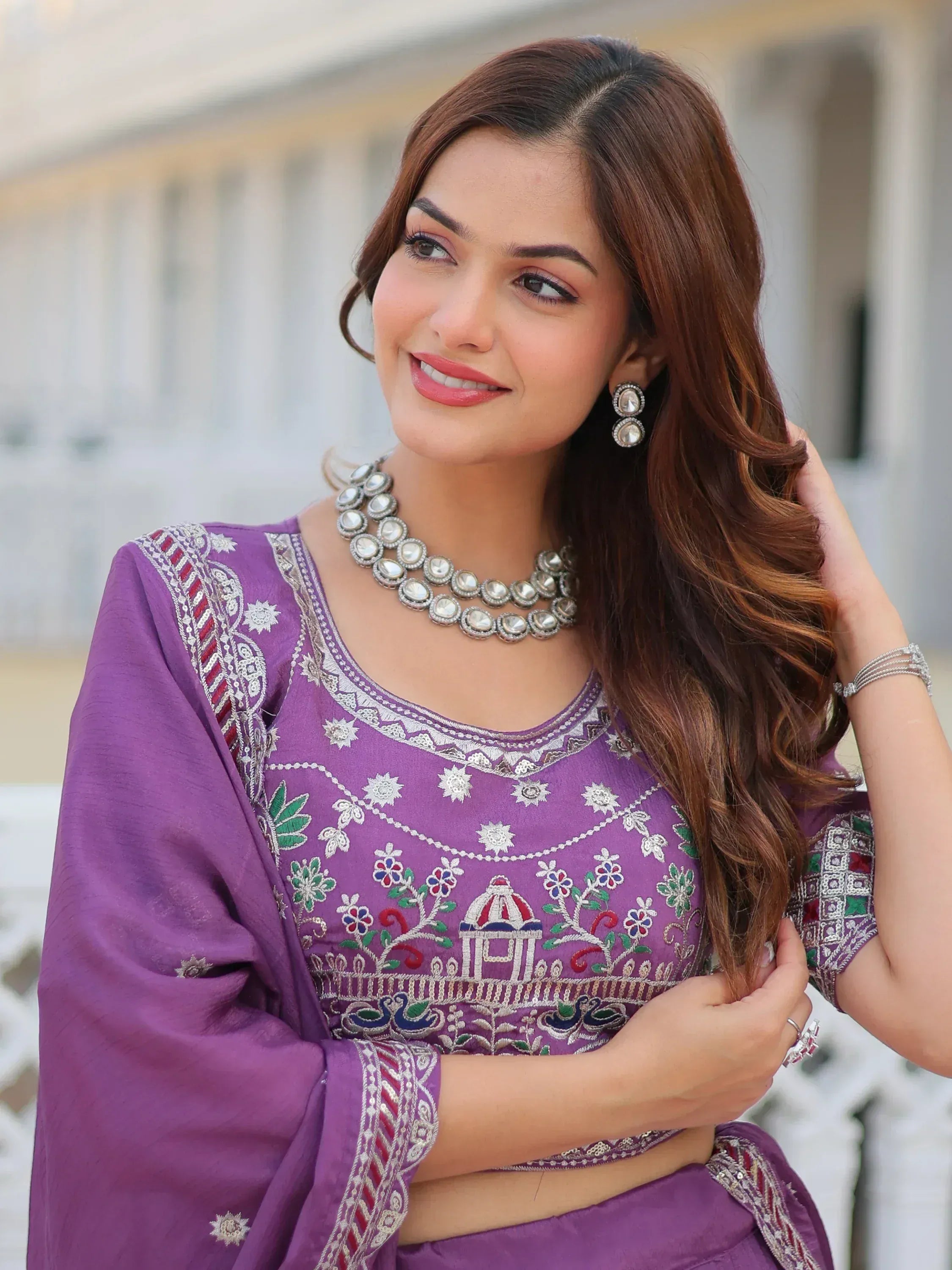 Purple embroidered ethnic blouse with mirror work, paired with traditional jewelry for Indian wear