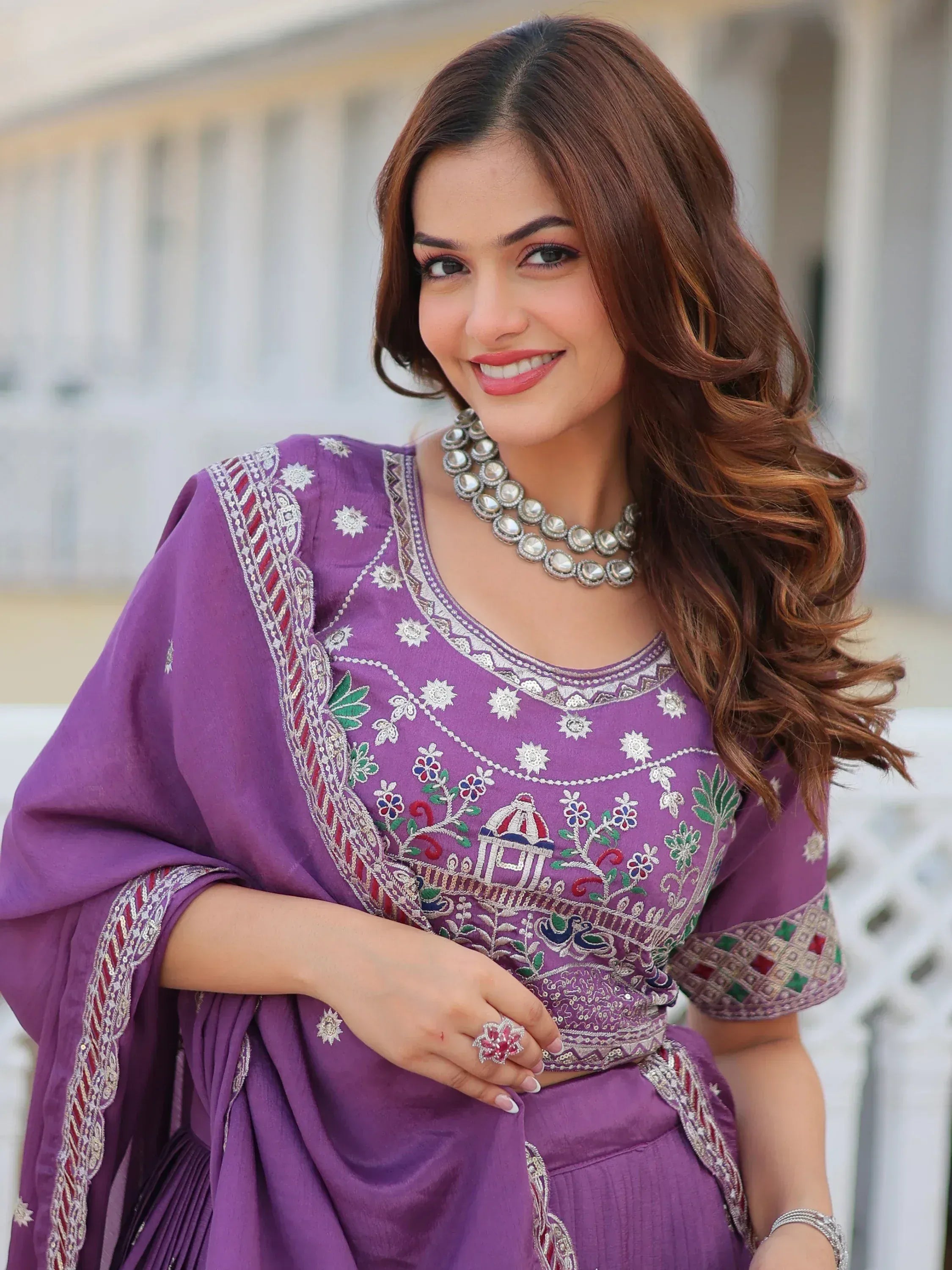 Purple embroidered salwar kameez with floral and temple motifs, perfect for Indian ethnic wear occasions.