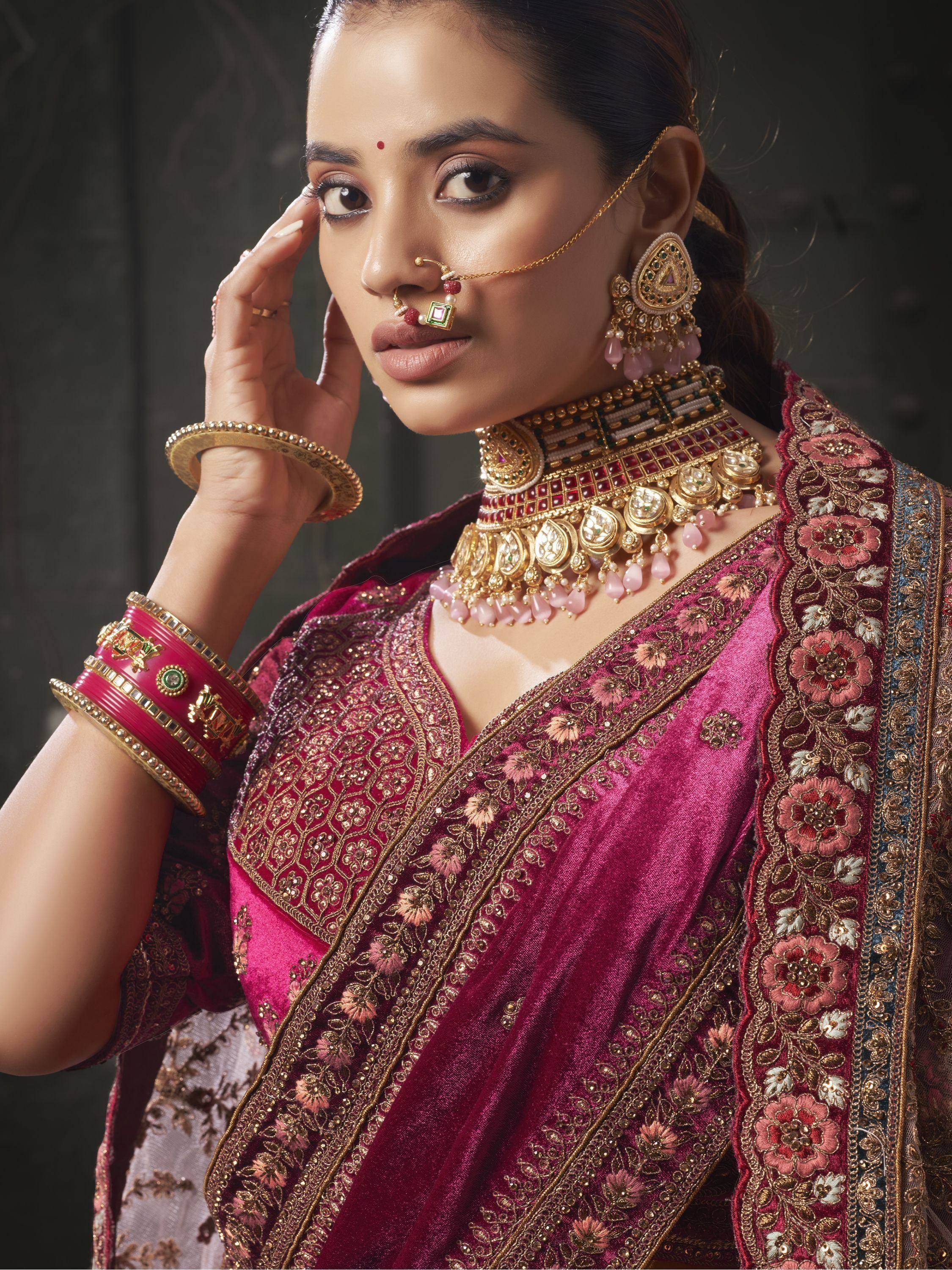 Woman in maroon embroidered saree with gold jewelry, traditional Indian ethnic wear