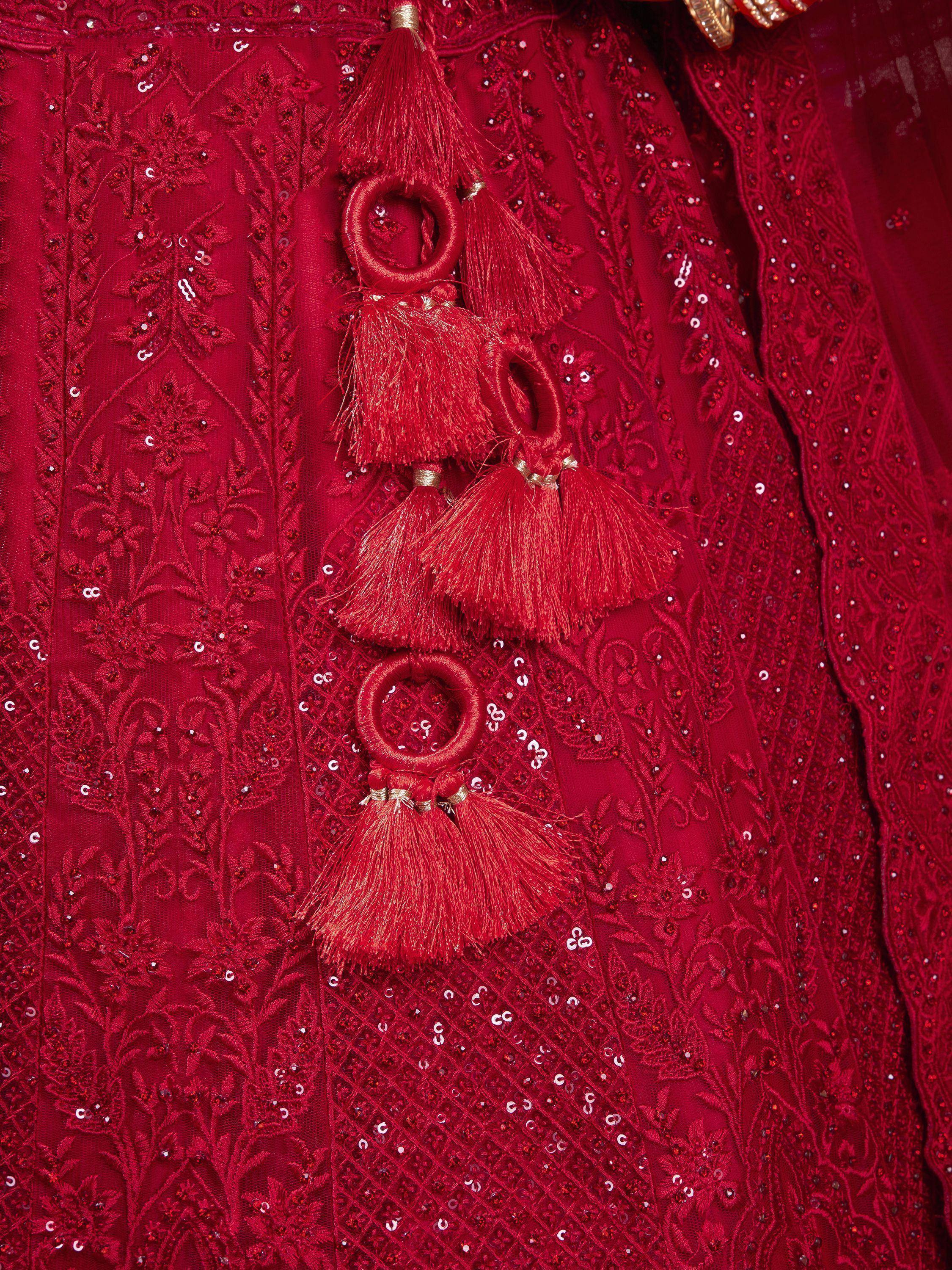 Red ethnic gown with intricate embroidery, sequins, and tassel details for festive occasions