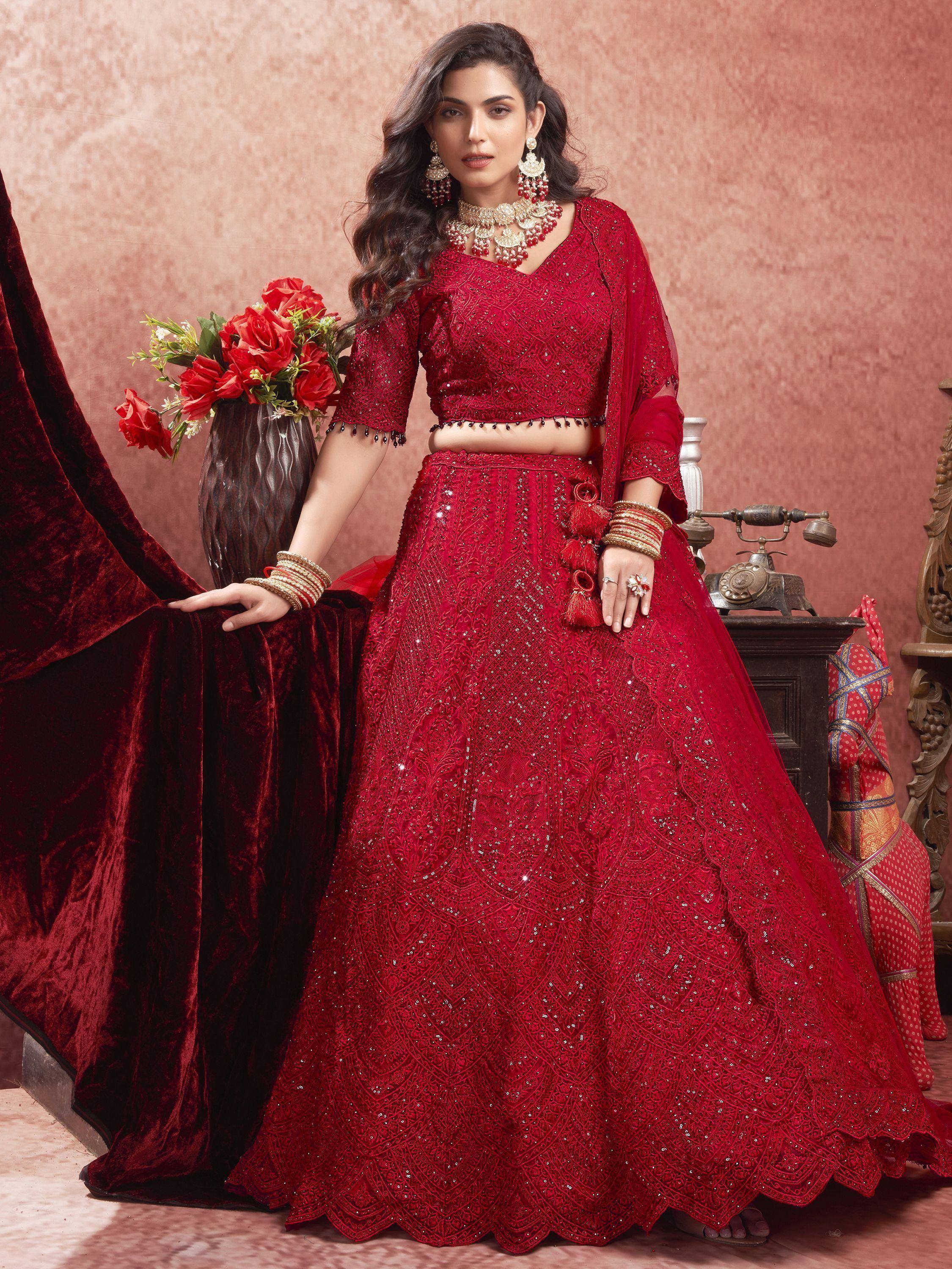 Red designer lehenga choli with intricate embroidery and sequins, perfect for Indian weddings and festive occasions.
