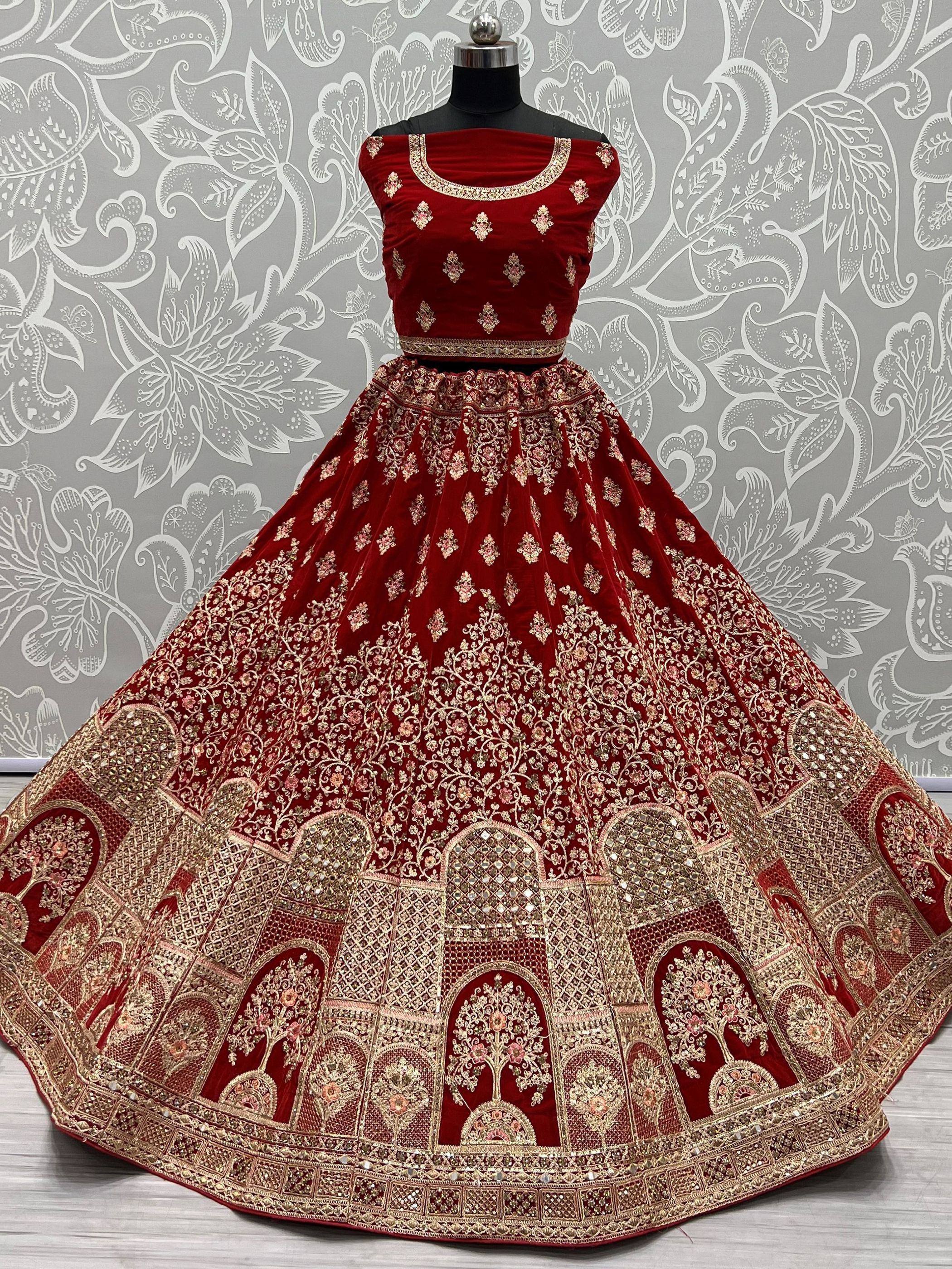 Red velvet designer lehenga choli with gold embroidery, perfect for Indian weddings and festive occasions.