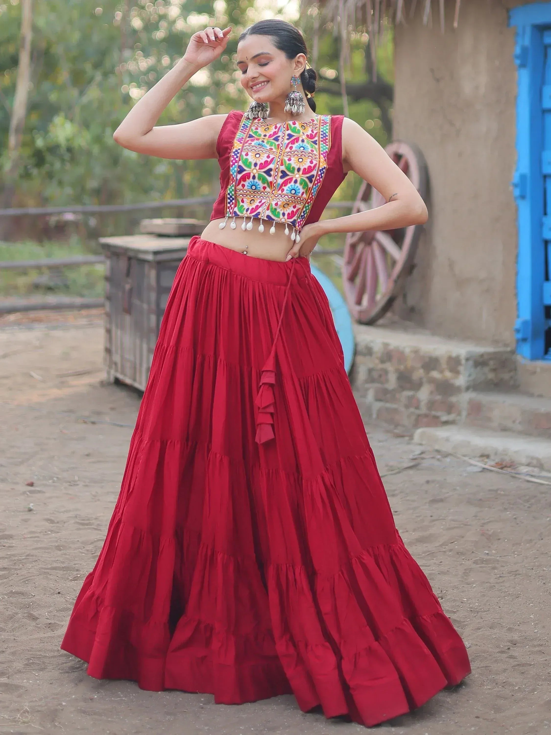 Red embroidered lehenga choli with colorful mirror work, perfect for Indian ethnic wear and festive occasions.
