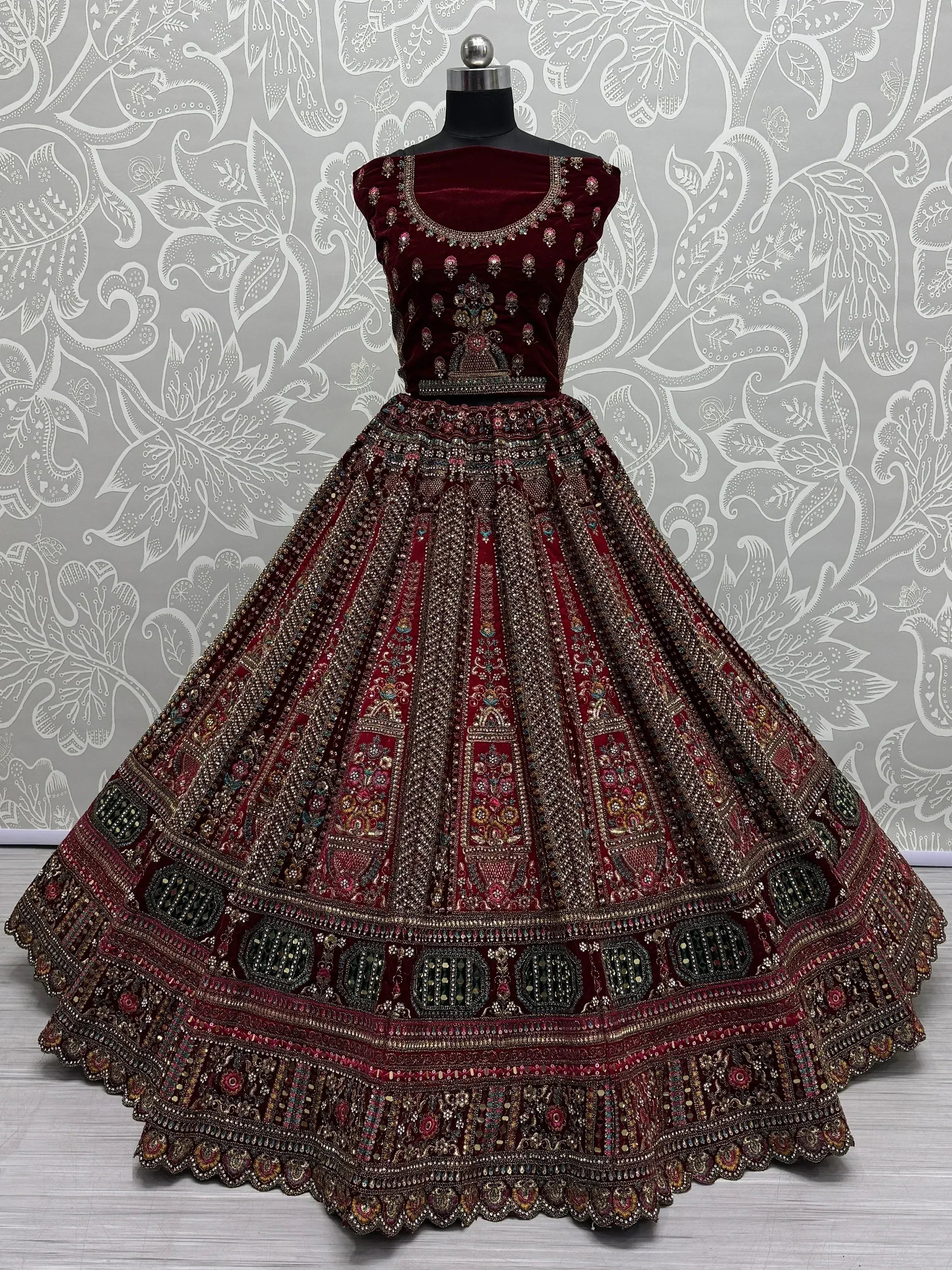 Maroon velvet lehenga choli with heavy embroidery and mirror work, perfect for Indian weddings and festive occasions.