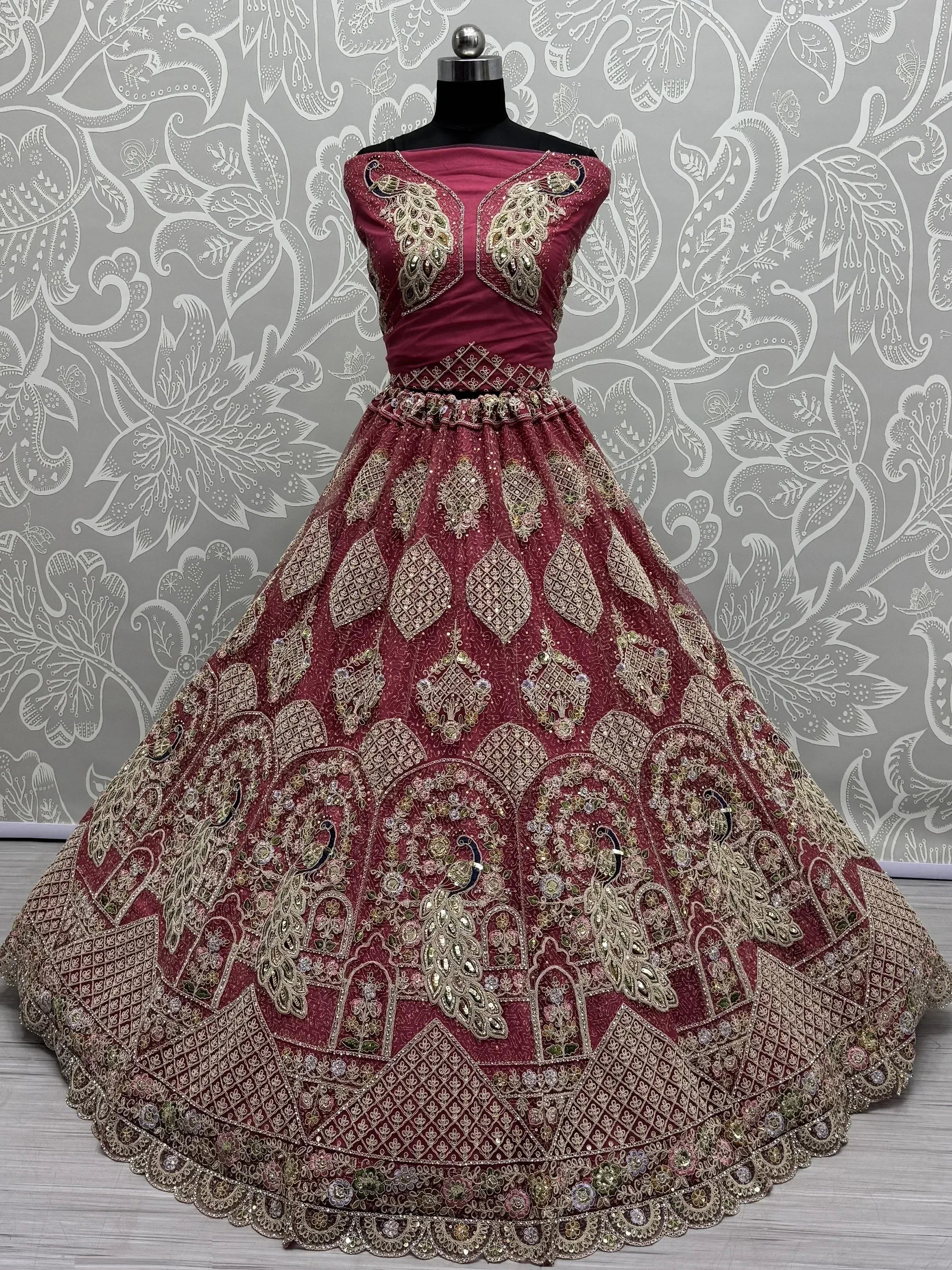 Maroon designer lehenga choli with peacock embroidery and gold zari work, perfect for weddings and festive occasions.