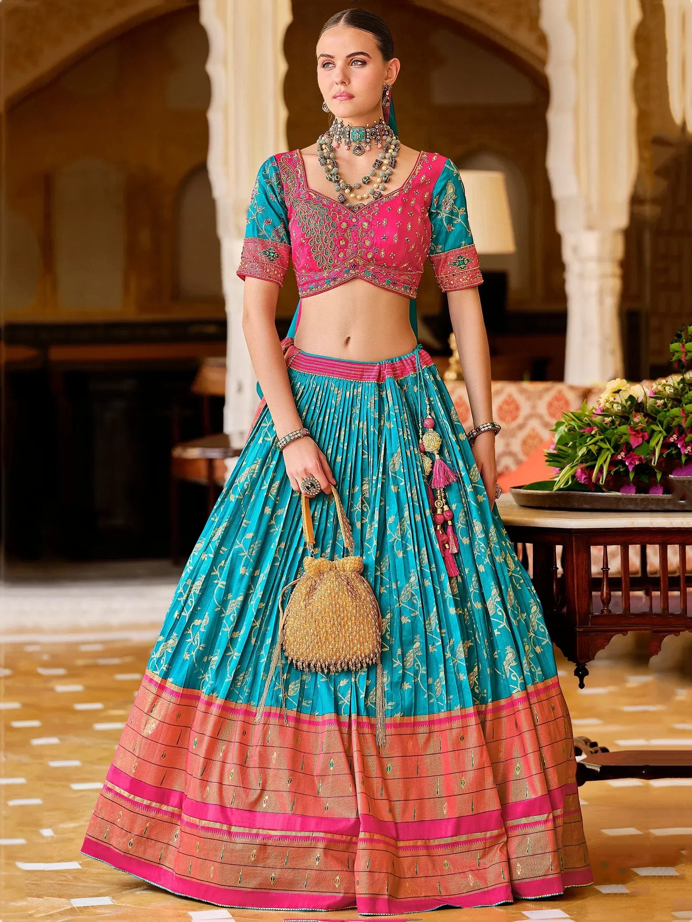 Teal and pink designer lehenga choli with gold embroidery, perfect for Indian ethnic wear occasions.