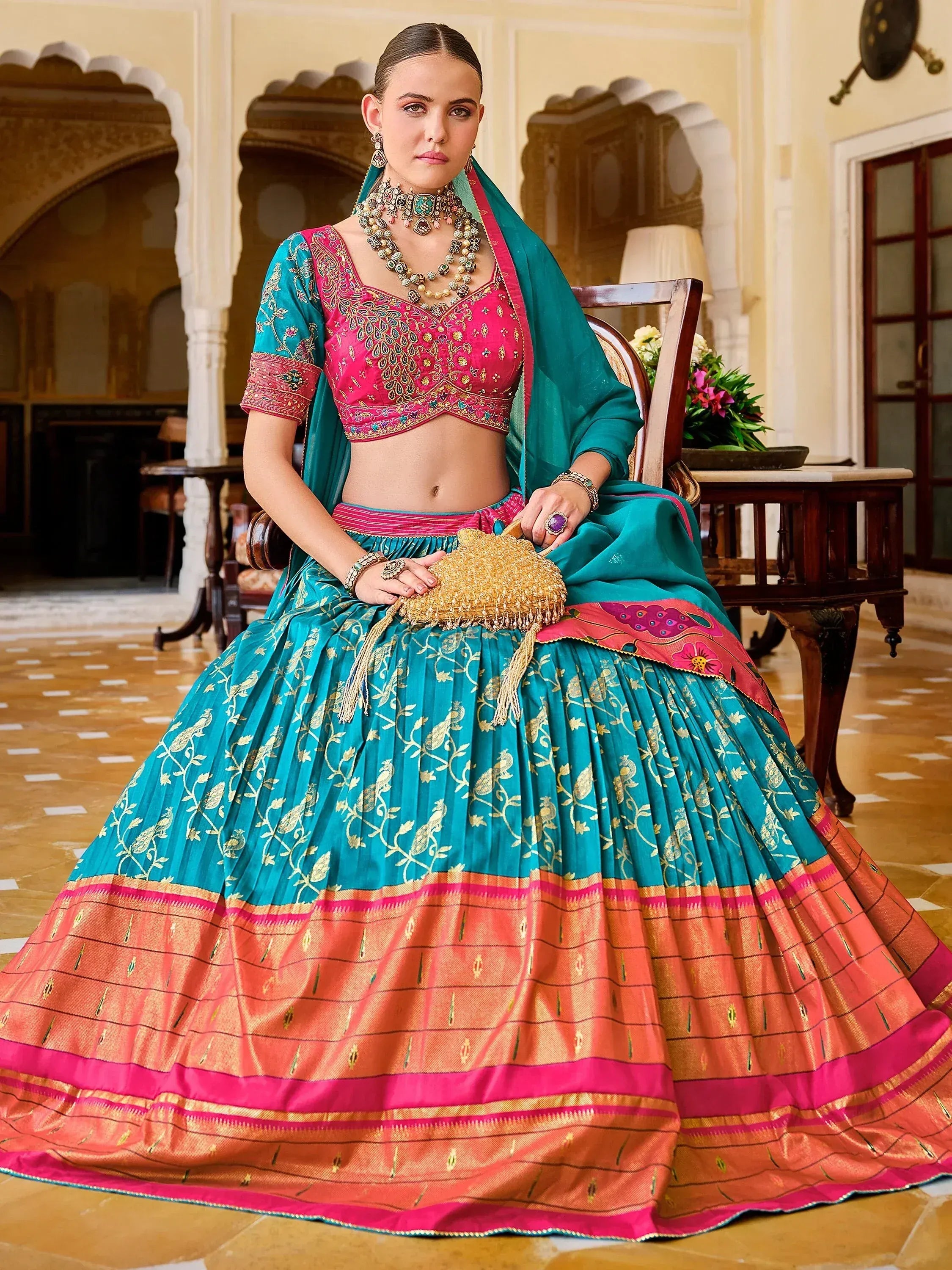 Teal and pink embroidered lehenga choli with gold detailing, perfect for Indian ethnic wear and festive occasions.