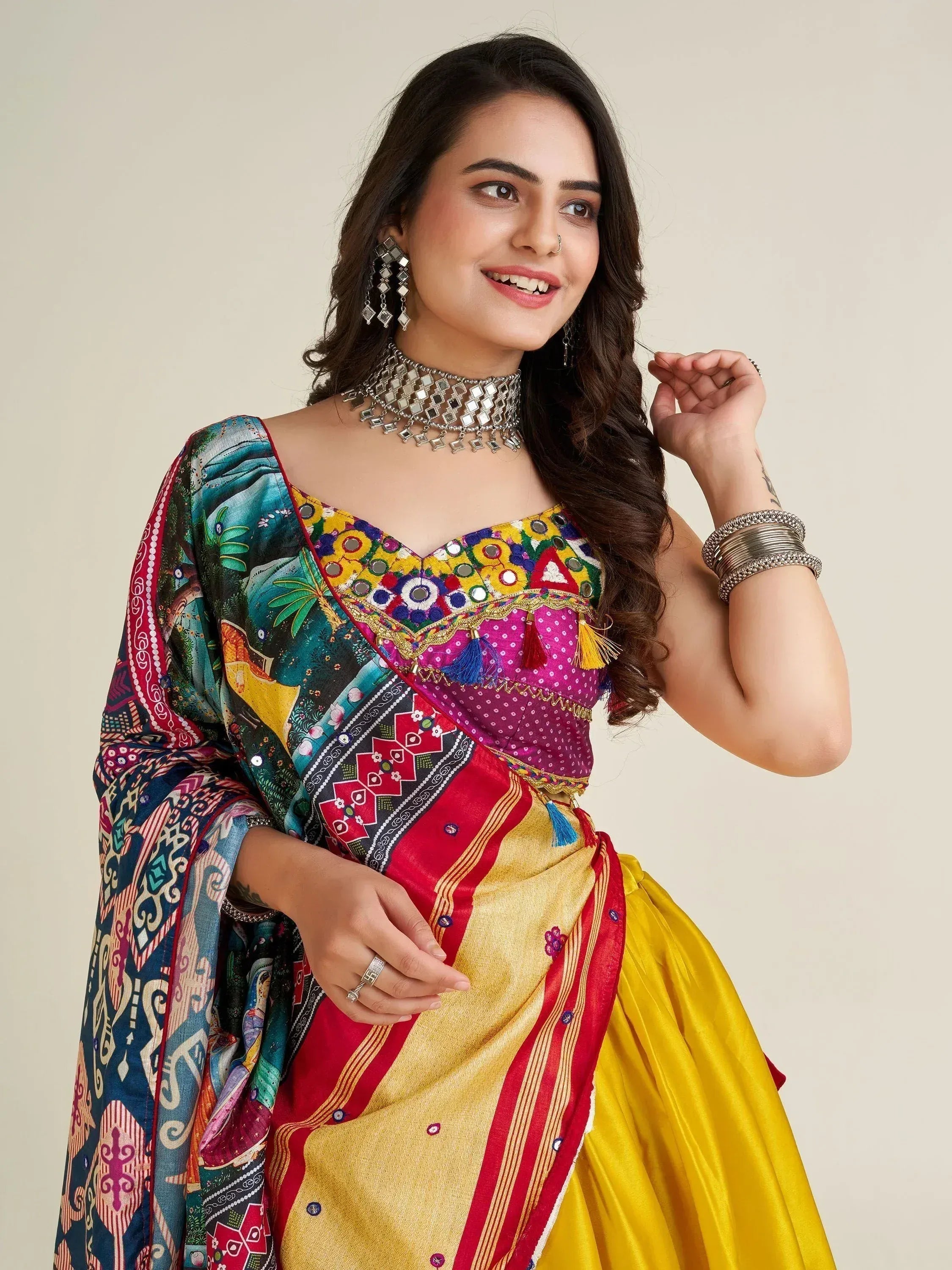 Woman in colorful Indian ethnic wear with mirror work blouse and yellow skirt, styled with traditional jewelry