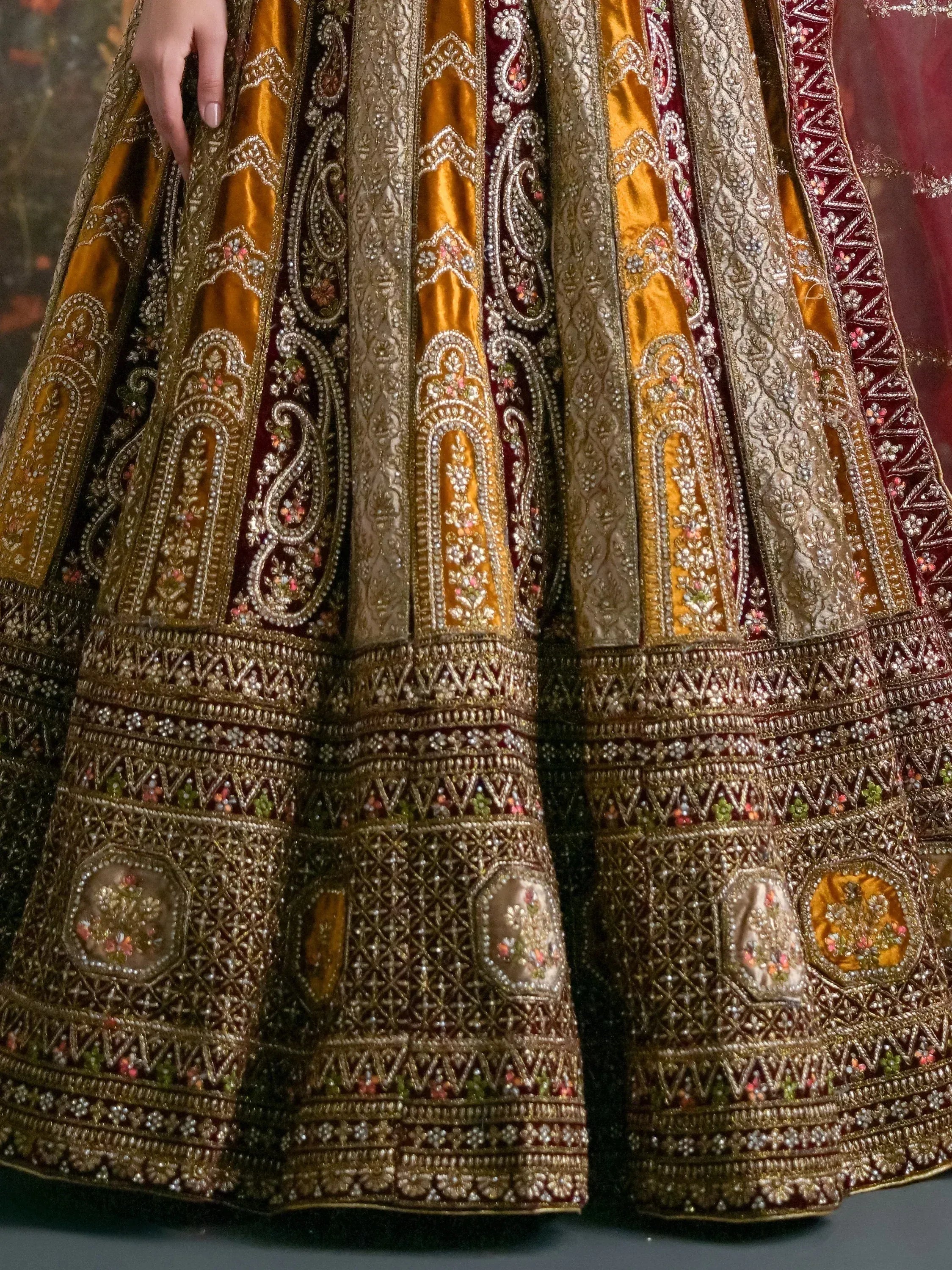 Luxury Indian lehenga choli with intricate gold and maroon embroidery, perfect for weddings and festive occasions.