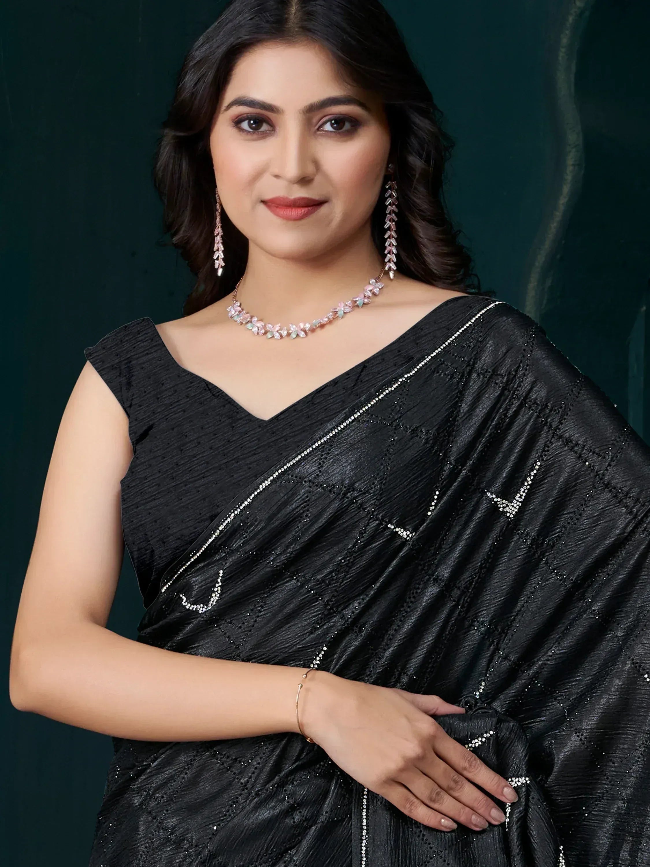Elegant black saree with sequin detailing, paired with floral jewelry for Indian ethnic wear